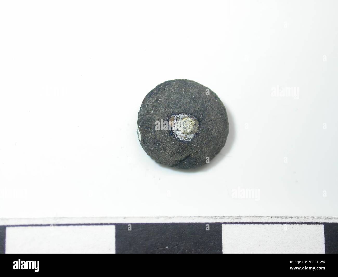 Clou décoratif, couleur sombre, taches de couleur or (alliage de cuivre). Arrondir et arrondir avec une goupille à travers. Le dos est creux et contient des restes de cuir. Il y a une plaque de finition à l'arrière de l'axe. La longueur de la broche n'est pas mesurable. Le diamètre de la plaque de finition est de 0,4 cm, course du tapis, métal, alliage de cuivre, Dm: 0,9 cm D: 0,6 cm, fin du XIVe siècle 1350-1400, Pays-Bas, Zélande, Hulst, Verdronken Land Banque D'Images