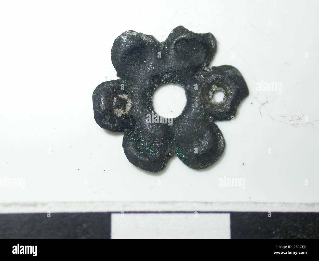 figurine à 6 lobed, dorée avec des taches sombres. (alliage de cuivre). figure à 6 lobed avec un trou au milieu. Le diamètre du trou est de 0,3 cm. Il y a un trou dans 2 lobes opposés. Probablement pour confirmation. Le dos est creux. Aucune confirmation visible., course de ceinture, métal, alliage de cuivre, Dm: 1,4 cm, D: 0,15 cm, fin du XIVe siècle 1350-1400, Pays-Bas, Zélande, Hulst, Verdronken Land Banque D'Images