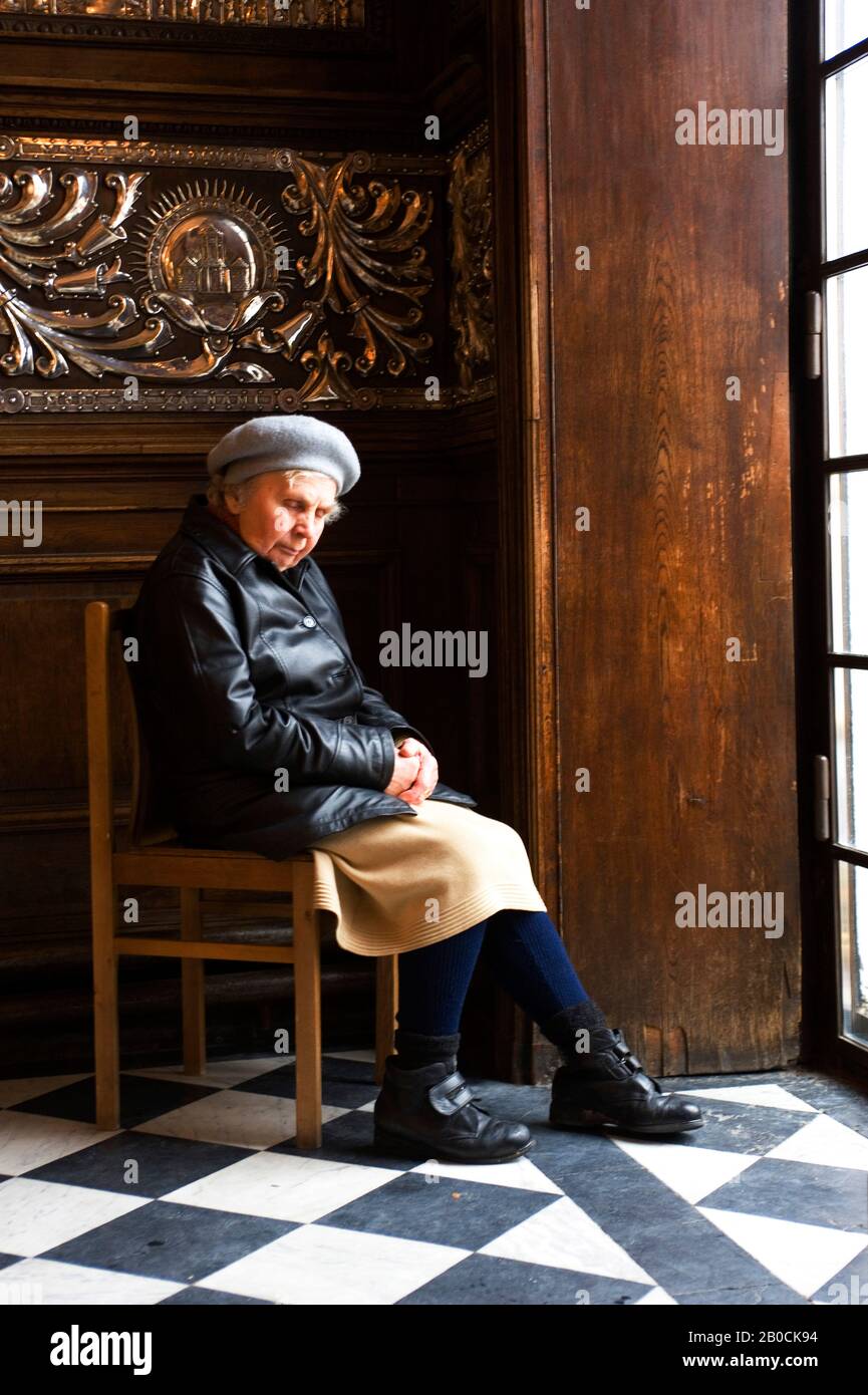 LITUANIE, VILNIUS, PORTES DE L'AUBE, CHAPELLE, VIEILLE FEMME SUR LA CHAISE, SIESTE Banque D'Images