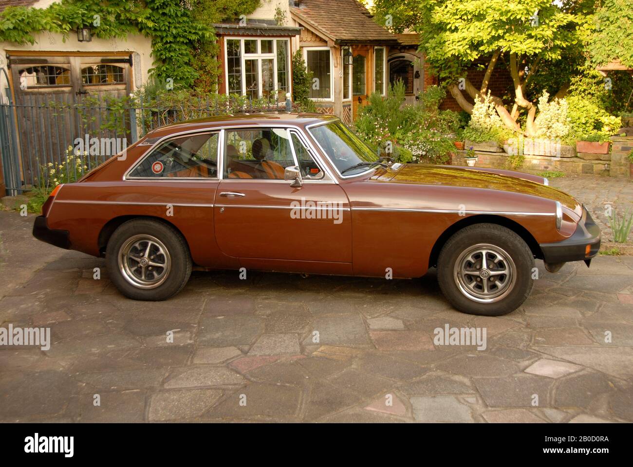 Voiture de sport marron MGB Gt Russet en voiture de la maison de banlieue Banque D'Images