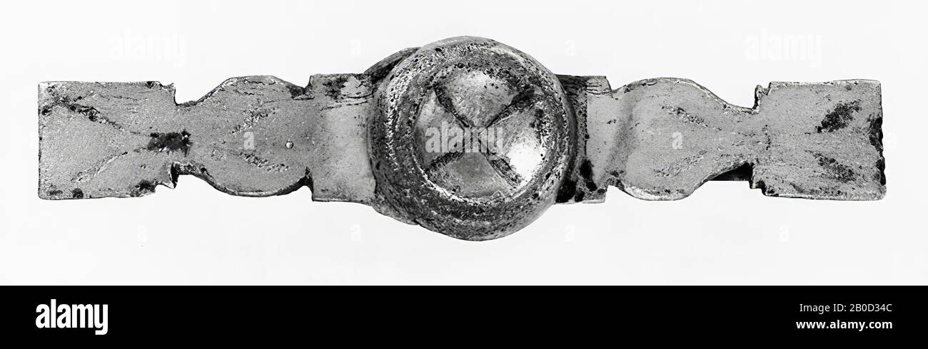 Bande de bronze argenté. Au milieu, il est plus ou moins ovale et allongé aux extrémités avec deux paires d'encoches des deux côtés, de sorte que la bande des deux côtés de la partie centrale devient d'abord rectangulaire, puis ovale, puis rectangulaire. Dans les pièces rectangulaires extrêmes, il y a aussi 1 paire d'encoches. Décoration avec des tiges qui se terminent dans les feuilles. Dans le trou de goupille de la section centrale, un disque profilé d'une Taille d'environ Égale est fixé à l'aide d'une goupille. Une bande de bronze (avec extrémités arrondies) traverse longitudinalement le dos de la bande et est maintenue en place aux deux extrémités par une tige et dans le Banque D'Images