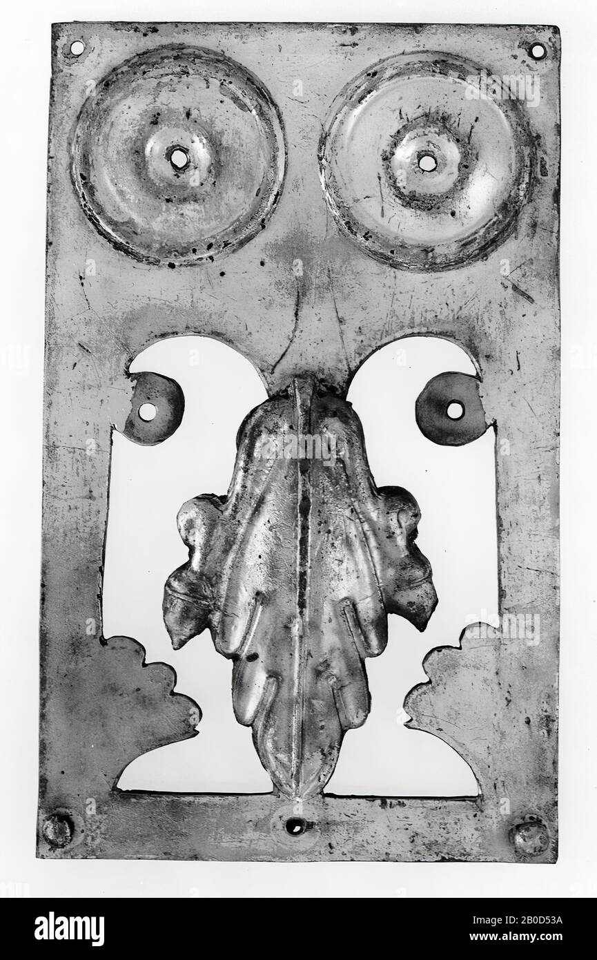 Plaque rectangulaire en bronze plaqué argent. En haut, il y a deux ornements circulaires (avec un contre-batteur milieu de champ autour d'un trou d'épingle), autour desquels une bordure, d'abord convexe que contre-batteur, fermée par une arête épaisse) est chassé. En dessous, c'est un grand motif décoratif. Deux fenêtres archies sont coupées l'une à côté de l'autre. Sur l'extérieur des fenêtres, un cercle (avec un trou au milieu) et un motif en forme de ventilateur au bas, restent en bronze. Sur le mince, entre style séparant les deux fenêtres, un ornement est soudé: Une feuille convexe de chêne avec un ornement des deux côtés. À l'arrière se trouvent sur le Banque D'Images