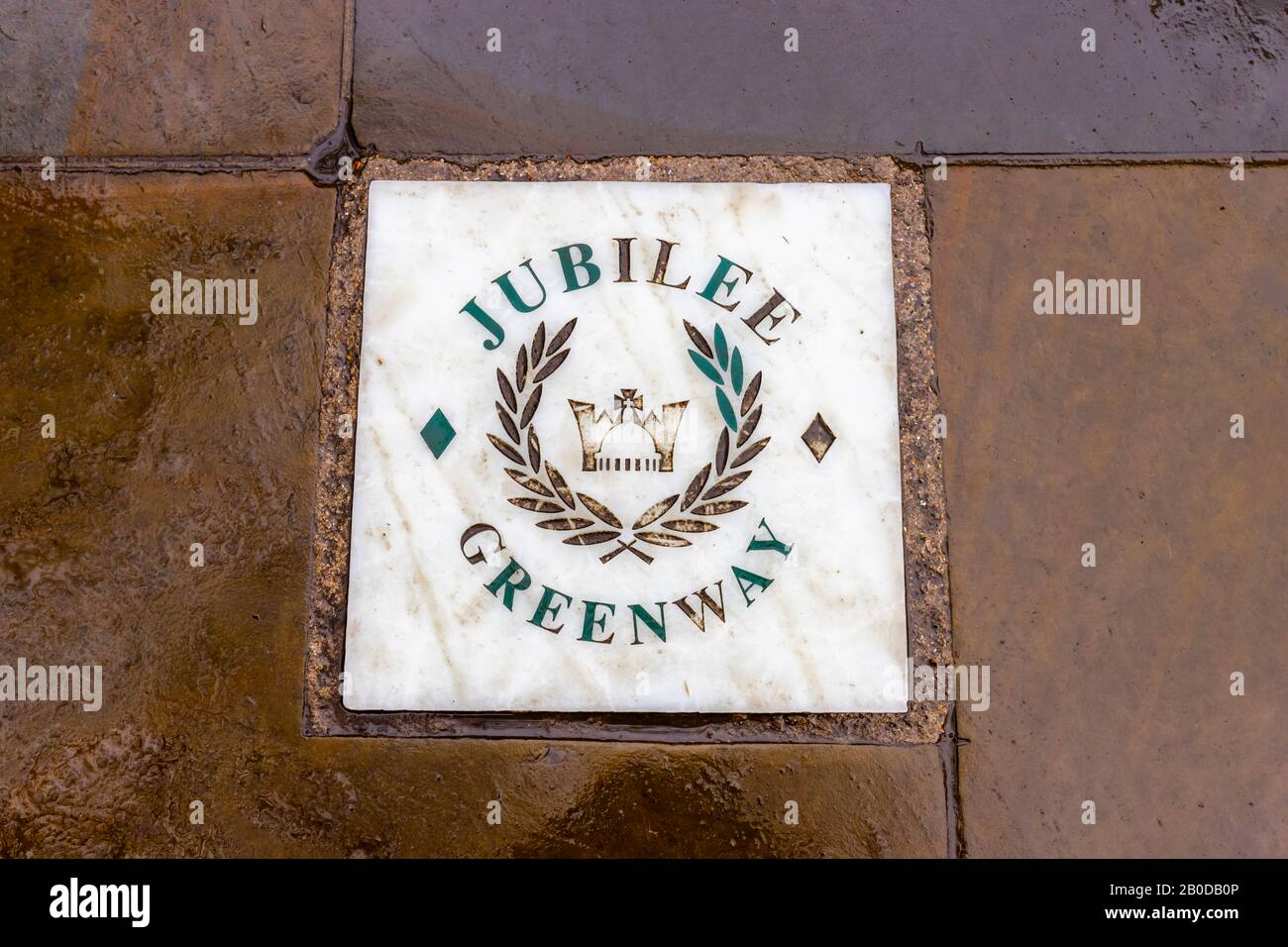 Tuile de nom pour le Jubilee Greenway sur la Promenade de la Reine sur la rive sud de la Tamise Embankment, Londres par temps humide Banque D'Images