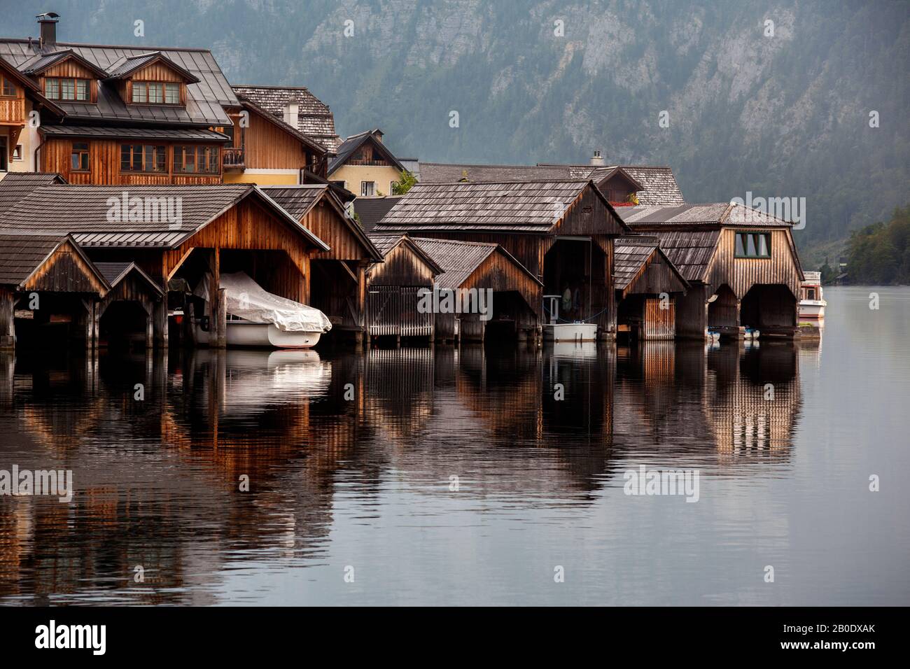 Une rangée de vieux hangars en bois dans l'eau sur le lac tôt le matin. Halstatt Autriche Banque D'Images