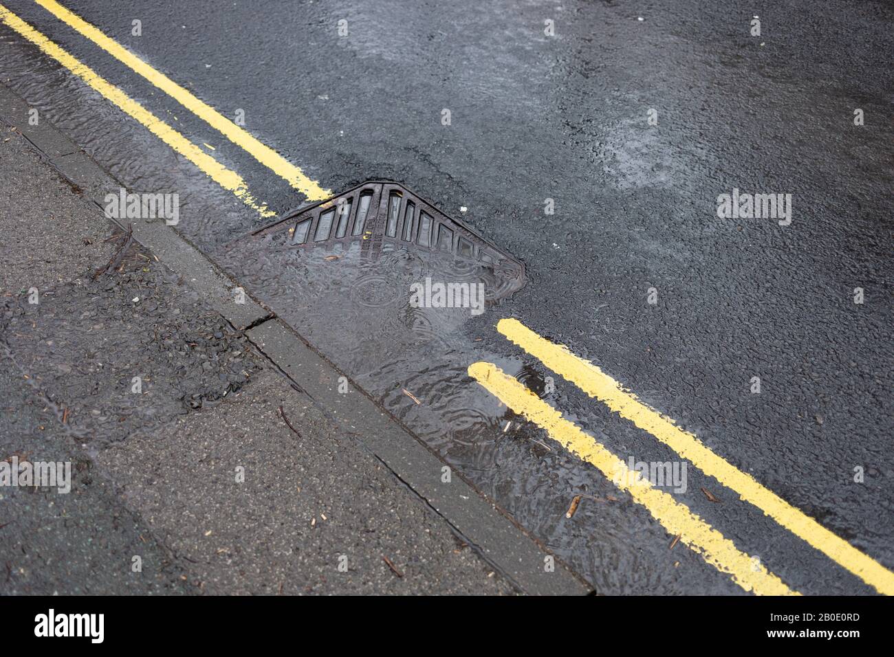 Une grille de drainage routière bloquée débordant d'eau de pluie à Saddleworth, Oldham, Royaume-Uni Banque D'Images