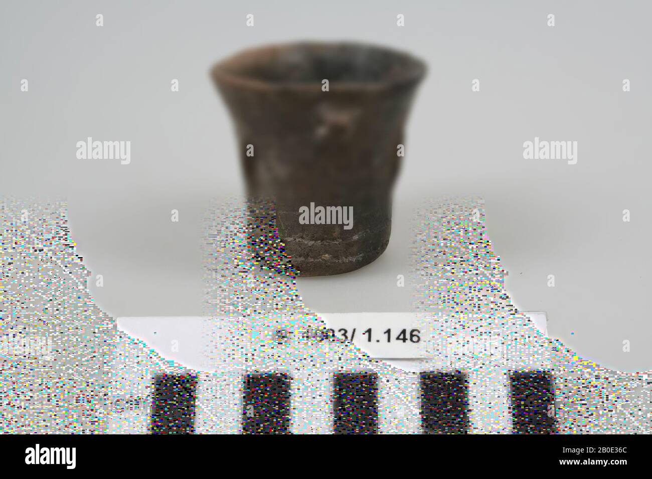 Une tasse en faïence brun-gris avec une bordure extérieure. L'objet est décoré avec des encoches primitives, remplies à l'origine d'une pâte blanche., vaisselle, poterie, H 5.8 cm, D 6.2 cm, fer Age I 1100-1000 BC, Iran Banque D'Images