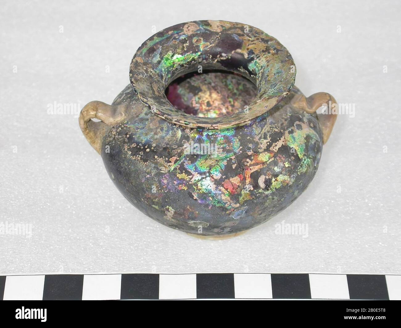 Petit bocal de verre noir, violet-rouge translucide. Anneau de support et oreilles de verre opaque, brun, vaisselle, verre, H 5 cm, Période romaine 100-300 AD, Syrie Banque D'Images