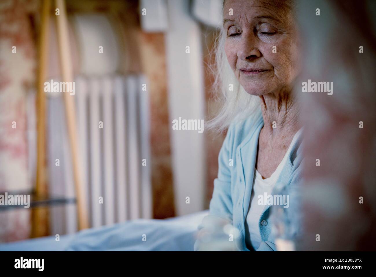 Senior woman sitting on bed Banque D'Images