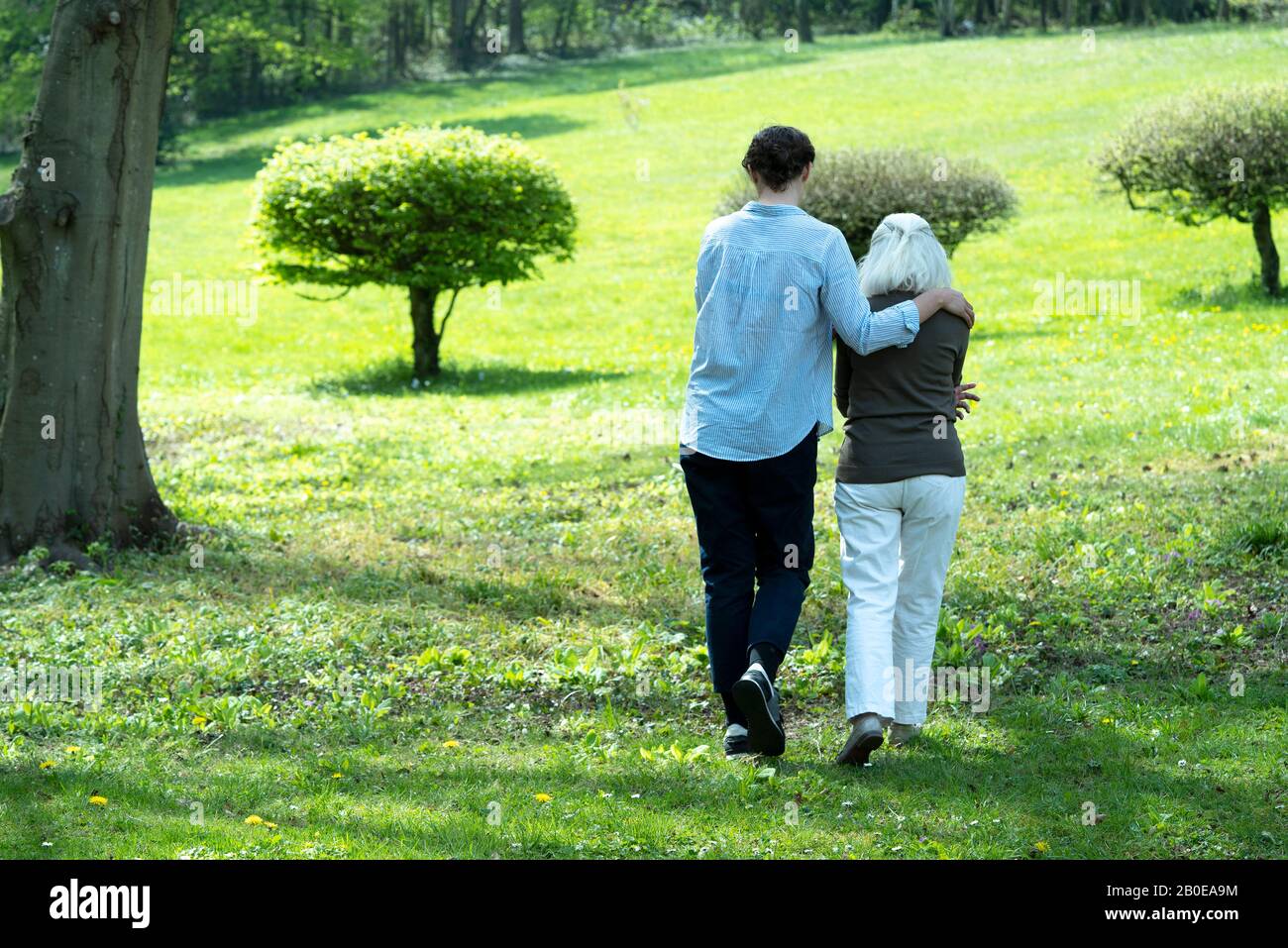 Soignant et femme senior marchant dans le jardin Banque D'Images