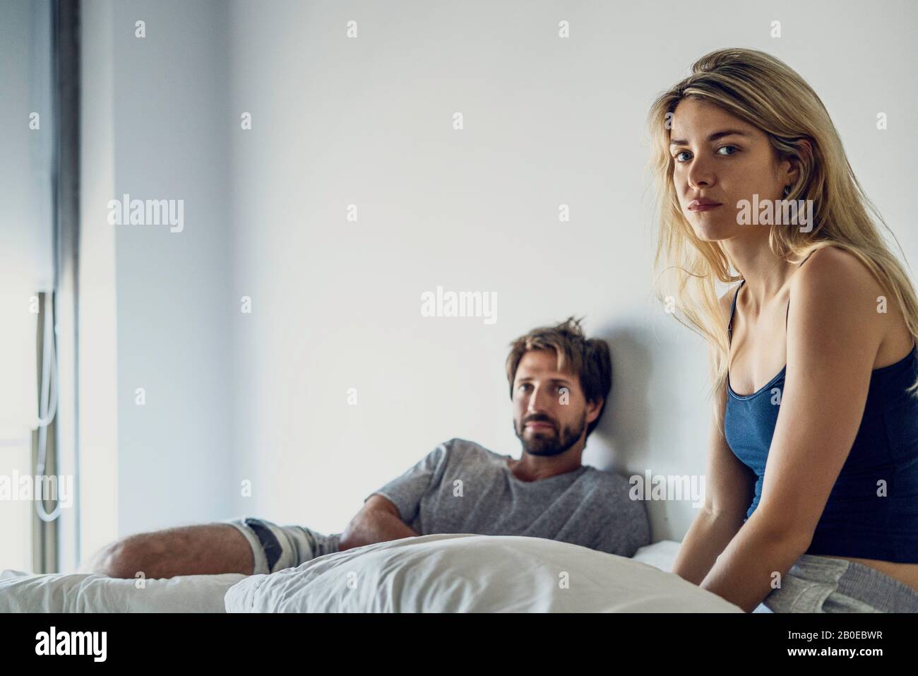 Young couple sitting on bed Banque D'Images