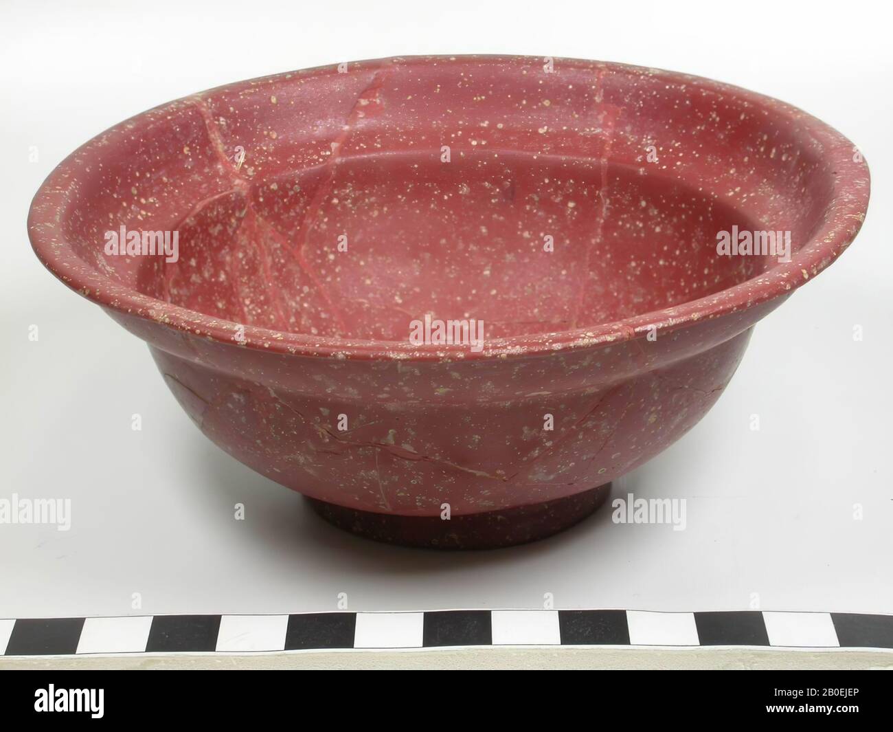 Bol grec-romain de pâte de verre rouge avec profilage simple. La surface en verre est légèrement mouchetée. Le plateau a été moulé Banque D'Images