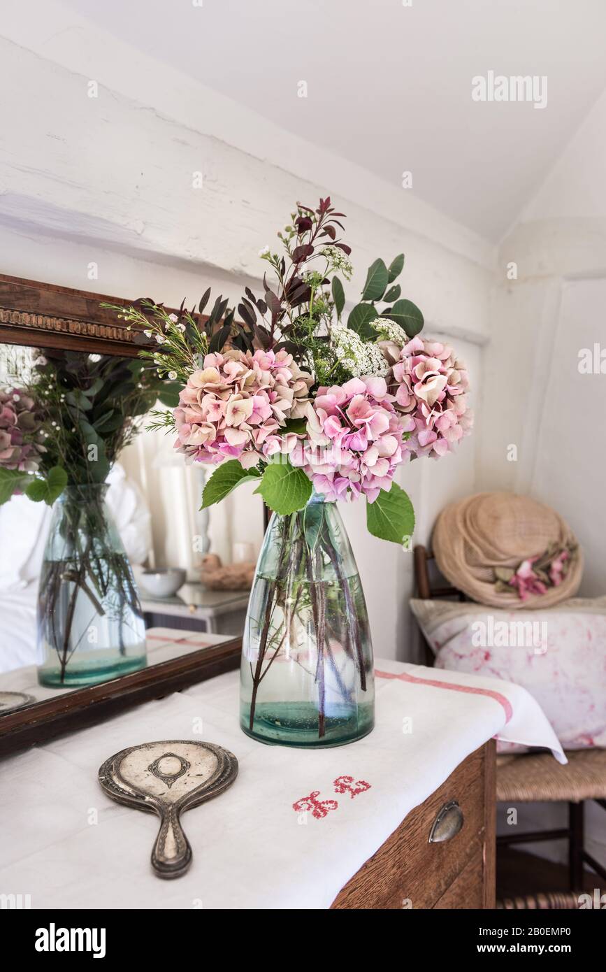 Hortensias roses avec miroir à main vintage et vase de Garden Trading reflétés dans le miroir ancien Banque D'Images