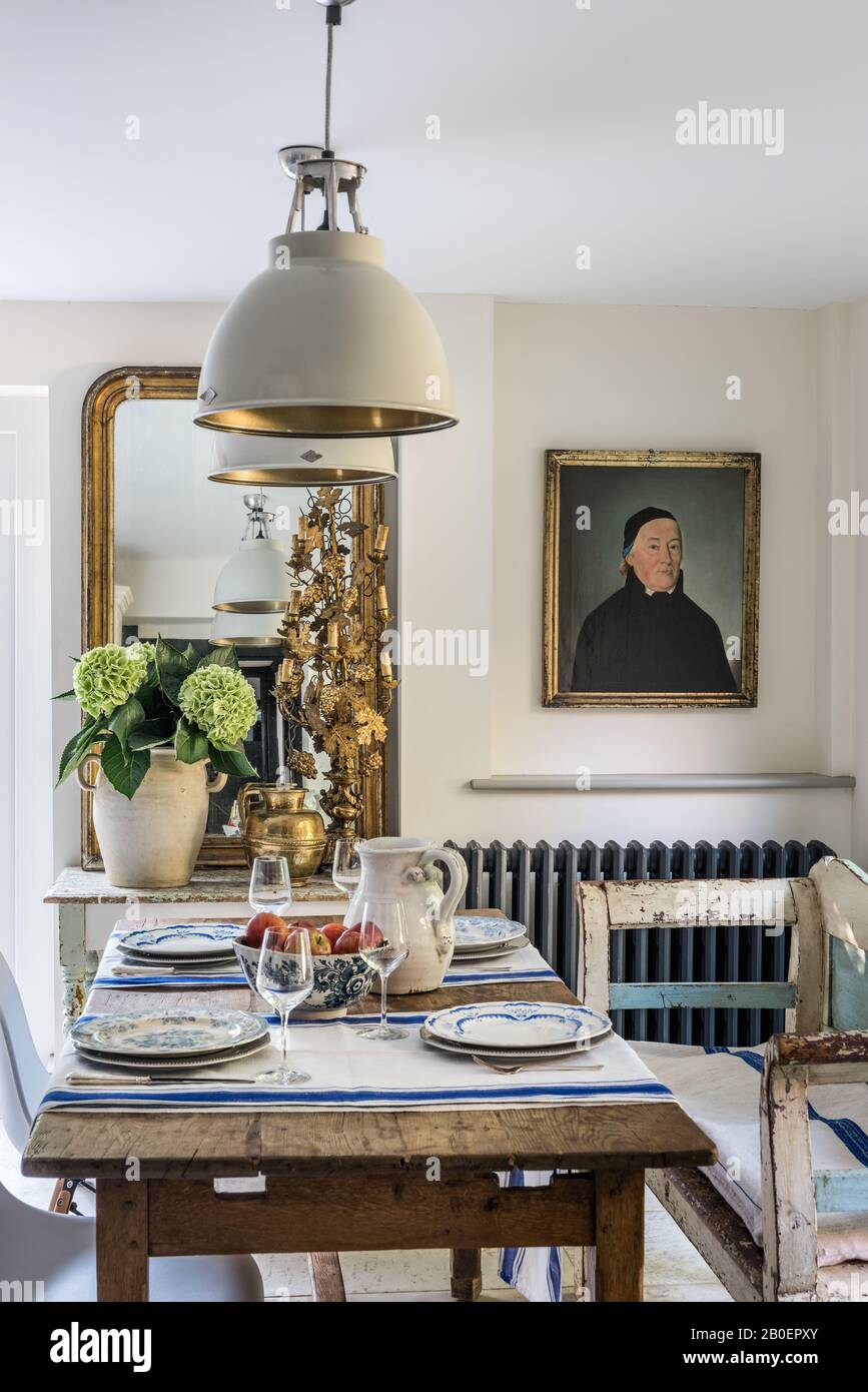 Le portrait d'un prêtre français du XIXe siècle est une salle à manger informelle avec table en chêne et banquette hongroise. Banque D'Images