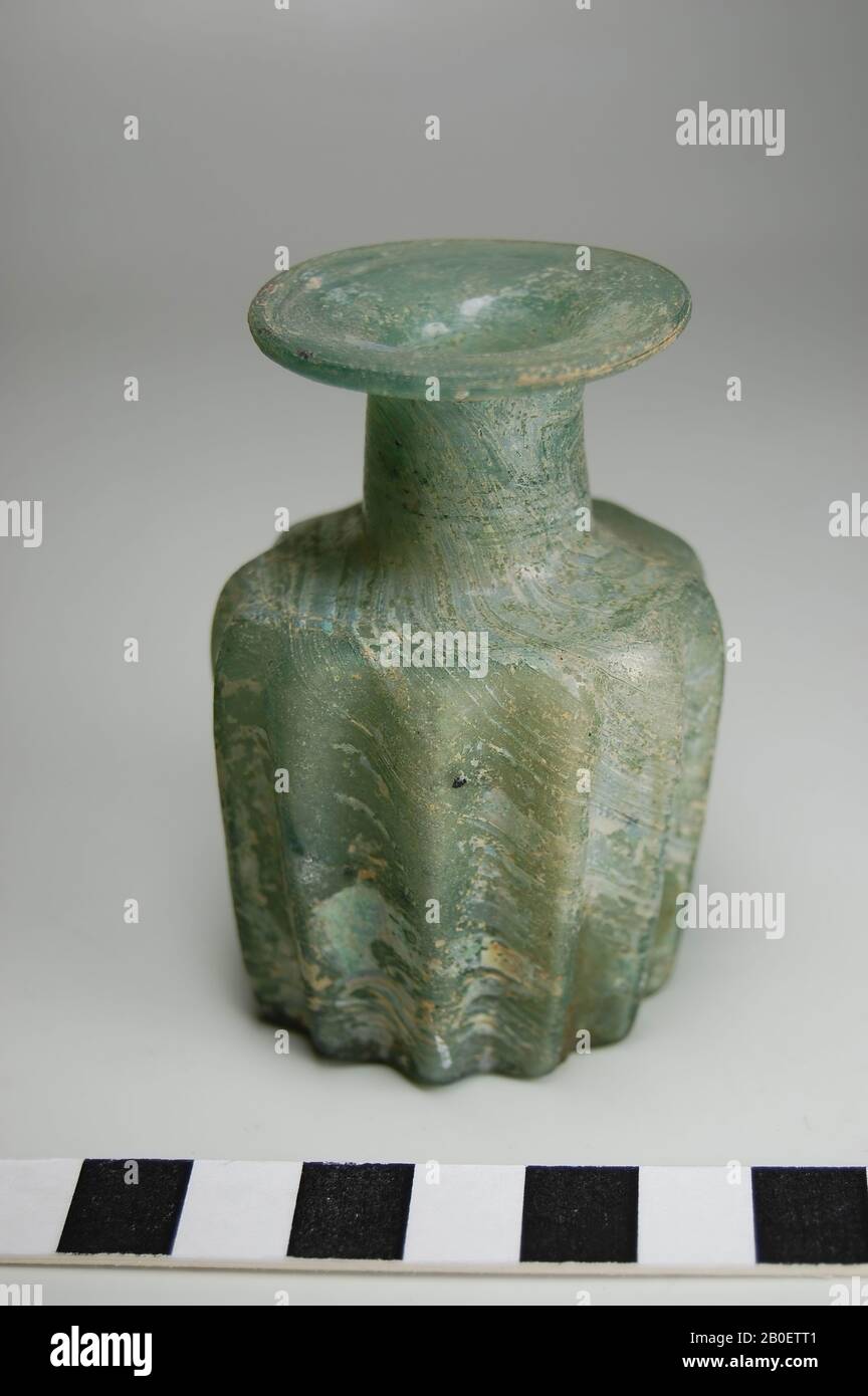 Bouteille, bouteille de parfum, bouteille de parfum sauté de forme en verre vert transparent. La bouteille a un corps cylindrique irrégulier avec douze nervures verticales triangulaires et un fond plat où la marque de pontil est visible. Un col court et cylindrique avec une lèvre plate en forme de disque à bord arrondi. Quelques impuretés foncées dans le verre., bouteille, verre, moisissure soufflée, h. 7,1 cm, diam. 4,9 cm, Période gréco-romaine, période impériale romaine 2ème-3ème siècle, Egypte Banque D'Images