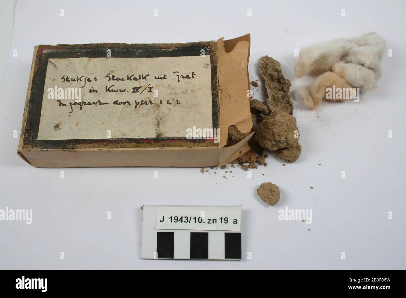 Fragments de coincé dans la boîte en carton avec de la laine de coton dedans. Texte sur la boîte: Morceaux de chaux bloquée de tombe dans Kww. IV Banque D'Images