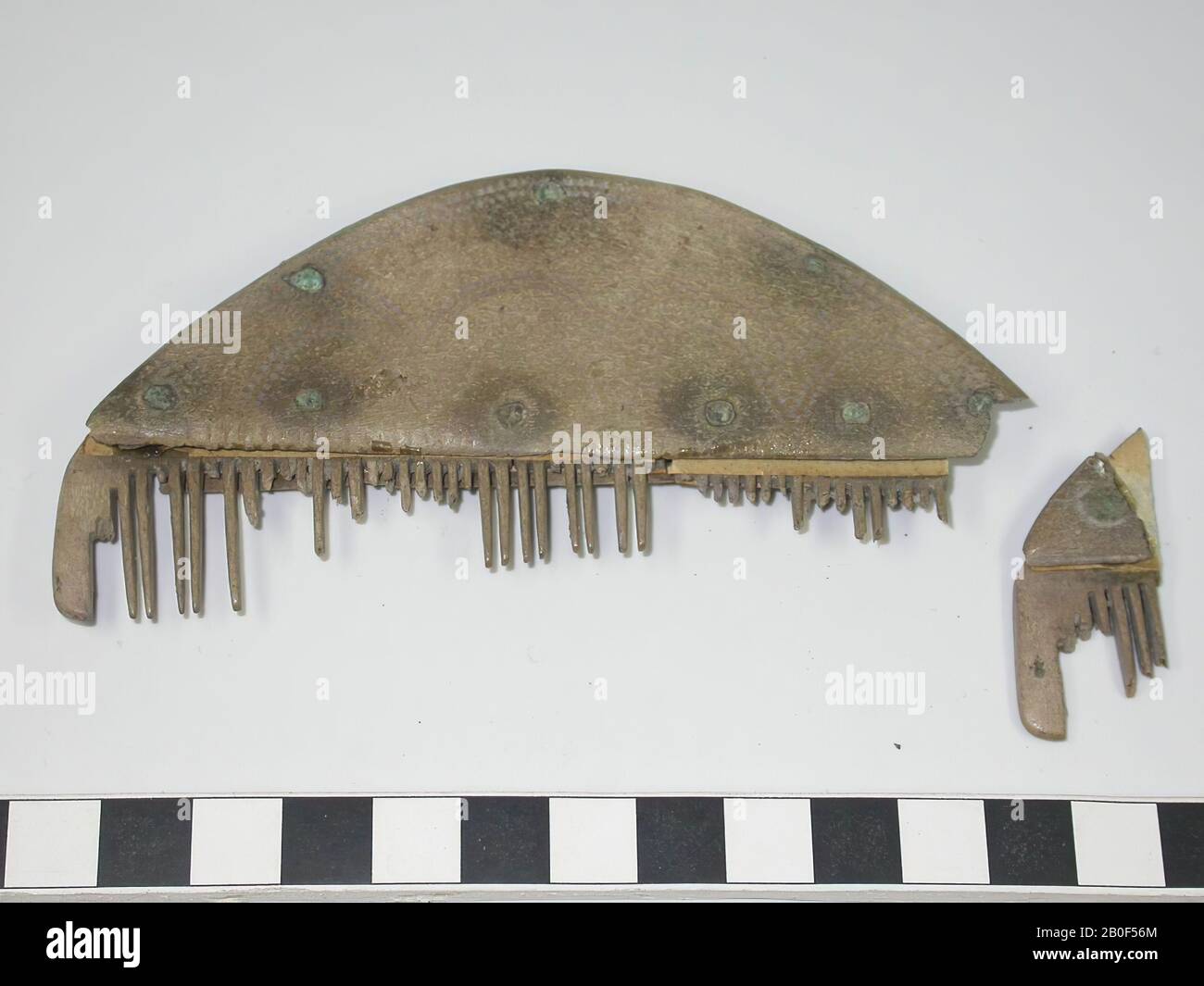 Sabot unilatéral à trois couches. Type : sabot semi-circulaire. Décoration: Poignées, belle ornementation de points sculptés, formant des lignes courbes (type de ligne d'onde). En outre, des points ont été coupés le long du sommet semi-circulaire de la lame de poignée, qui suit les lignes de la lame de poignée. Les deux côtés sont décorés de manière identique. Forme : base droite, sommet semi-circulaire. Plaques à dents: 5. Plaques d'extrémité: 2. (dont 1 est sorti du sabot). Dents: Dents entières: 13. Un certain nombre de dents se sont considérablement usées. Dents cassées: 42. Nombre original de dents: 55. Rivets : manipuler la lame avec la plaque de marquage collée sur : 7 Banque D'Images