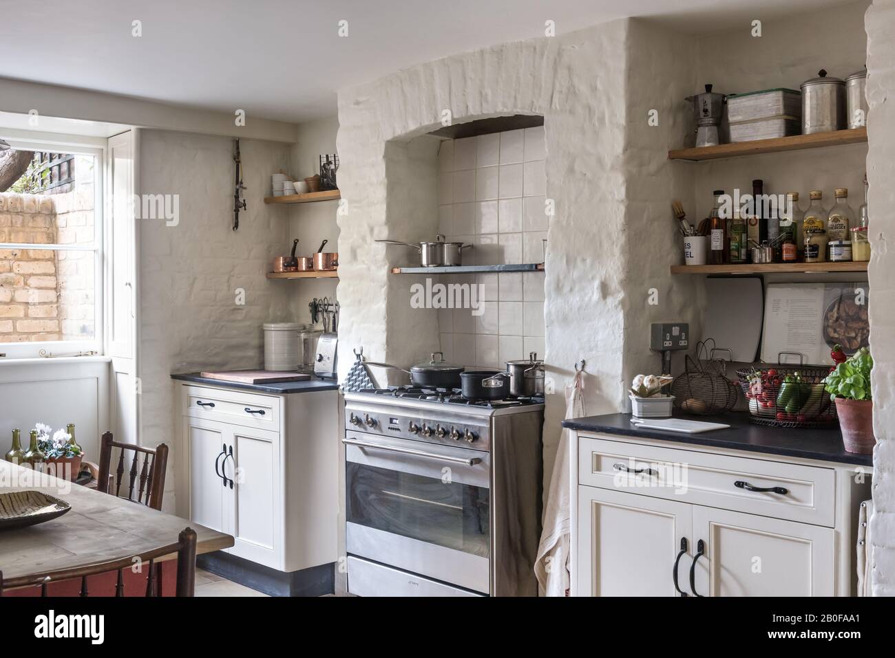 Stephen Pardy a récupéré des armoires de base avec des plateaux en ardoise et une cuisinière de la gamme Smeg dans une alcôve d'origine. Banque D'Images