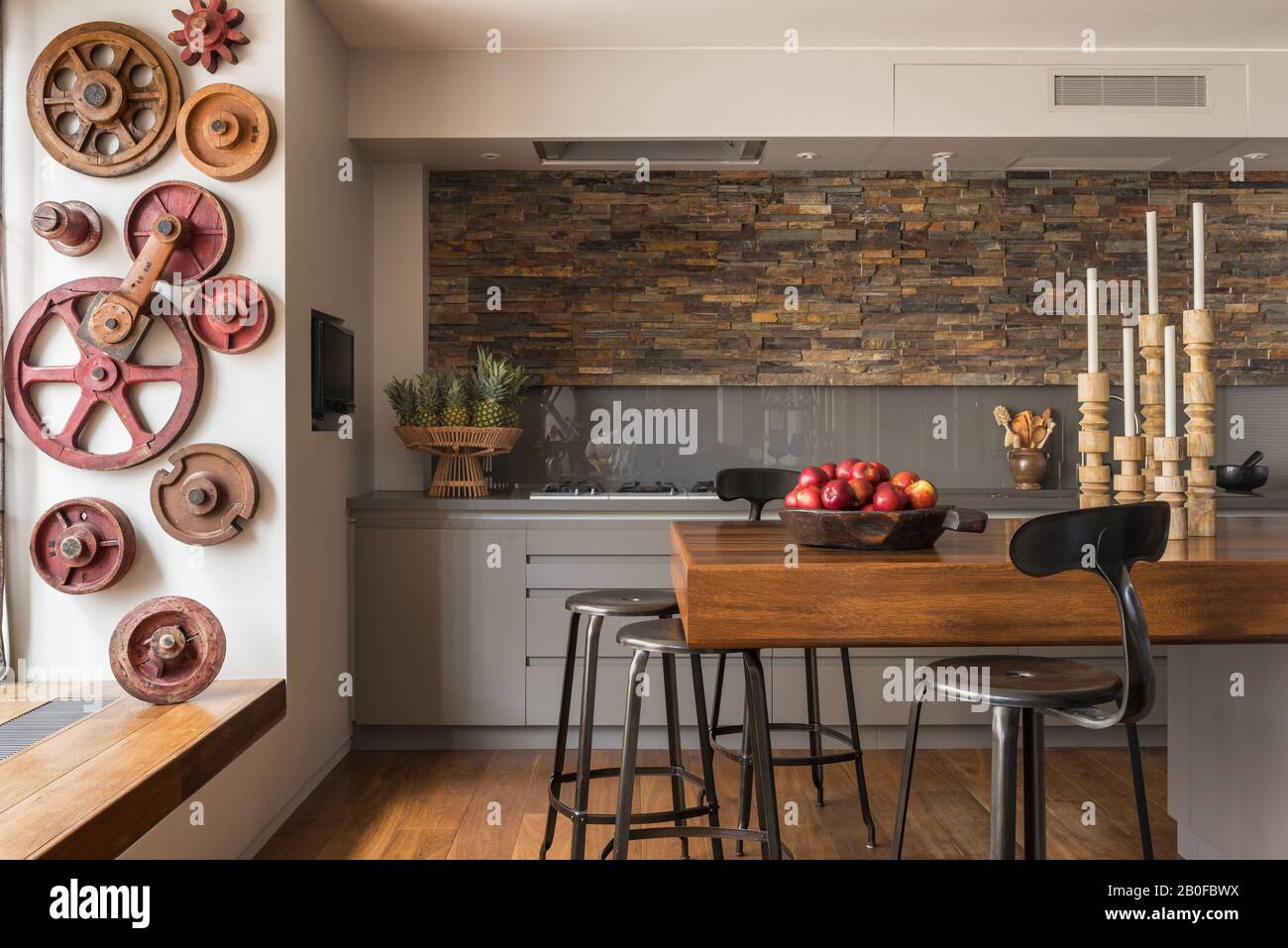 Bar à petit-déjeuner en teck avec murs ornés d'ardoise dans la cuisine de l'appartement moderne de West London. Banque D'Images