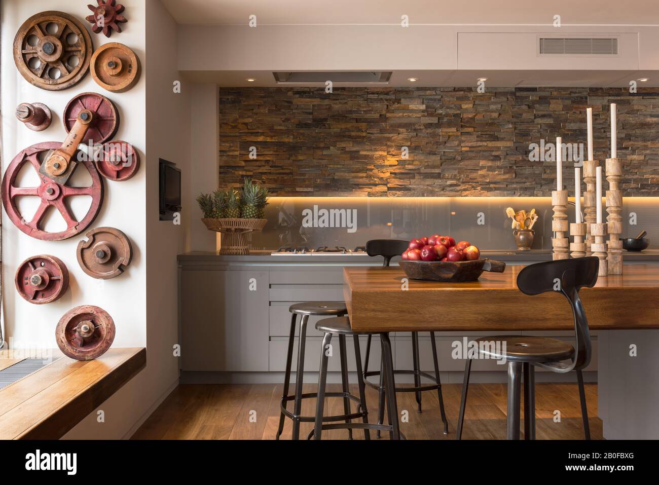 Bar à petit-déjeuner en teck avec murs ornés d'ardoise dans la cuisine de l'appartement moderne de West London. Banque D'Images