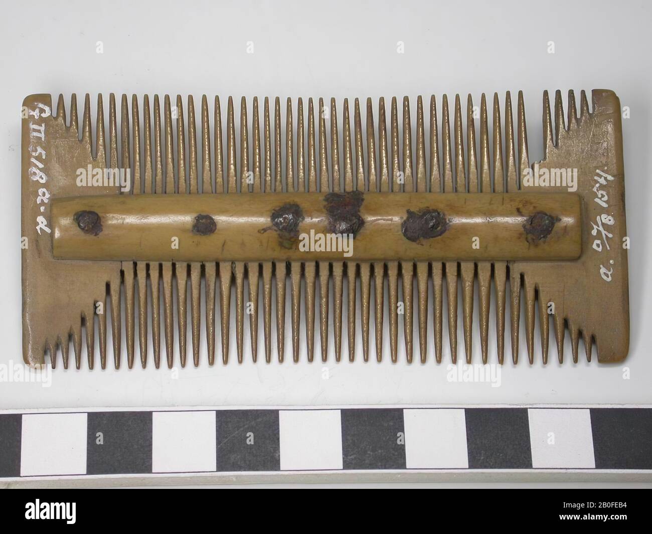 Sabot à trois couches recto verso. Type : sabot double face. Décoration: Manquante. Forme : rectangulaire. Les 2 lames de poignée sont arrondies et se trouvent au milieu du peigne.TandenRabat : 7. Nombre original de plaques de dents: 7. Dents cassées: 1. Dents entières : 41 d'un côté et 45 dents de l'autre côté. Nombre original de dents: 87. Rivets : 5., peigne, organique, antitler, l = 10 cm et b = 4,8 cm, Vmeb 550-700 Banque D'Images