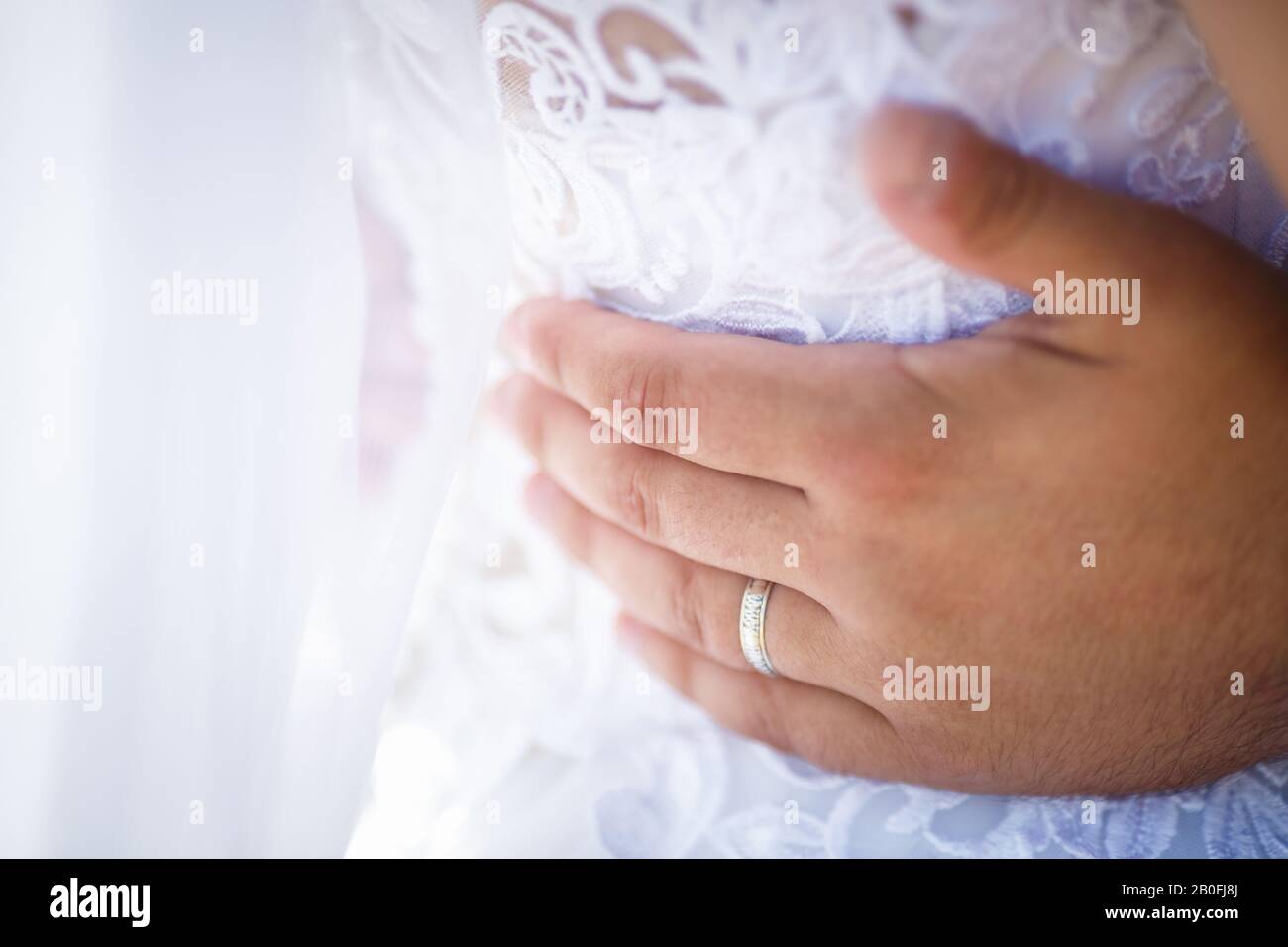 robe embrasse la mariée. les mains des jeunes mariés. robe avec dos ouvert Banque D'Images