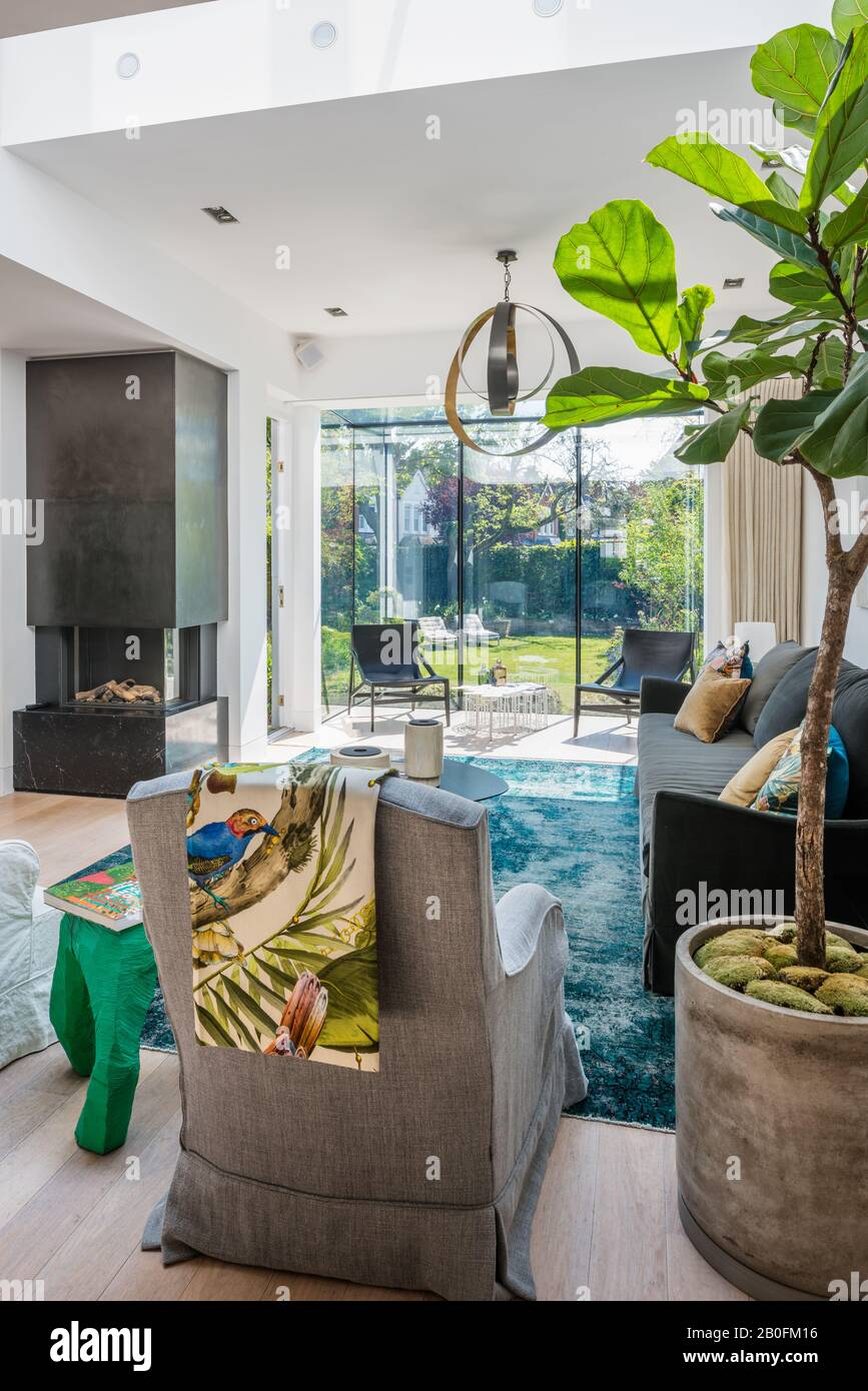 Fenêtre avec vue sur le jardin avec cheminée en bronze avec foyer en marbre et jet d'oiseau exotique Banque D'Images