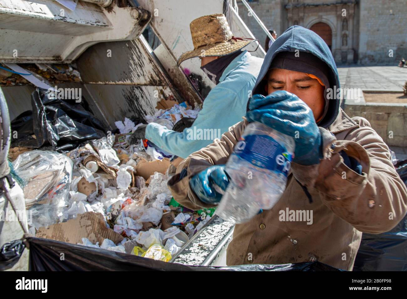 Oaxaca, Mexique - les collecteurs de déchets trient les matières recyclables d'autres ordures à l'arrière d'un camion à ordures. Banque D'Images