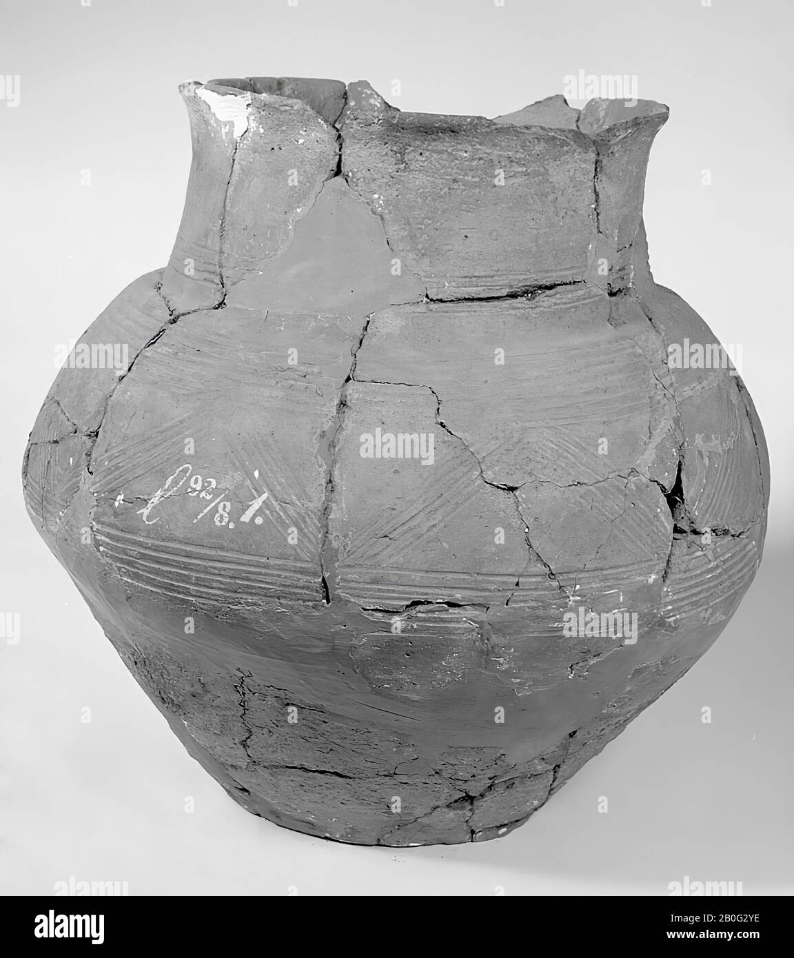 urne marron sphérique avec fond aplati et bord montant. Sur le ventre décoré de lignes parallèles séparées par des lignes en zigzag. Ici et là par le Finder avec des morceaux d'autres urnes, mais facilement reconnaissables, mis à jour, urne, poterie, hauteur: 37 cm, préhistoire -800 Banque D'Images