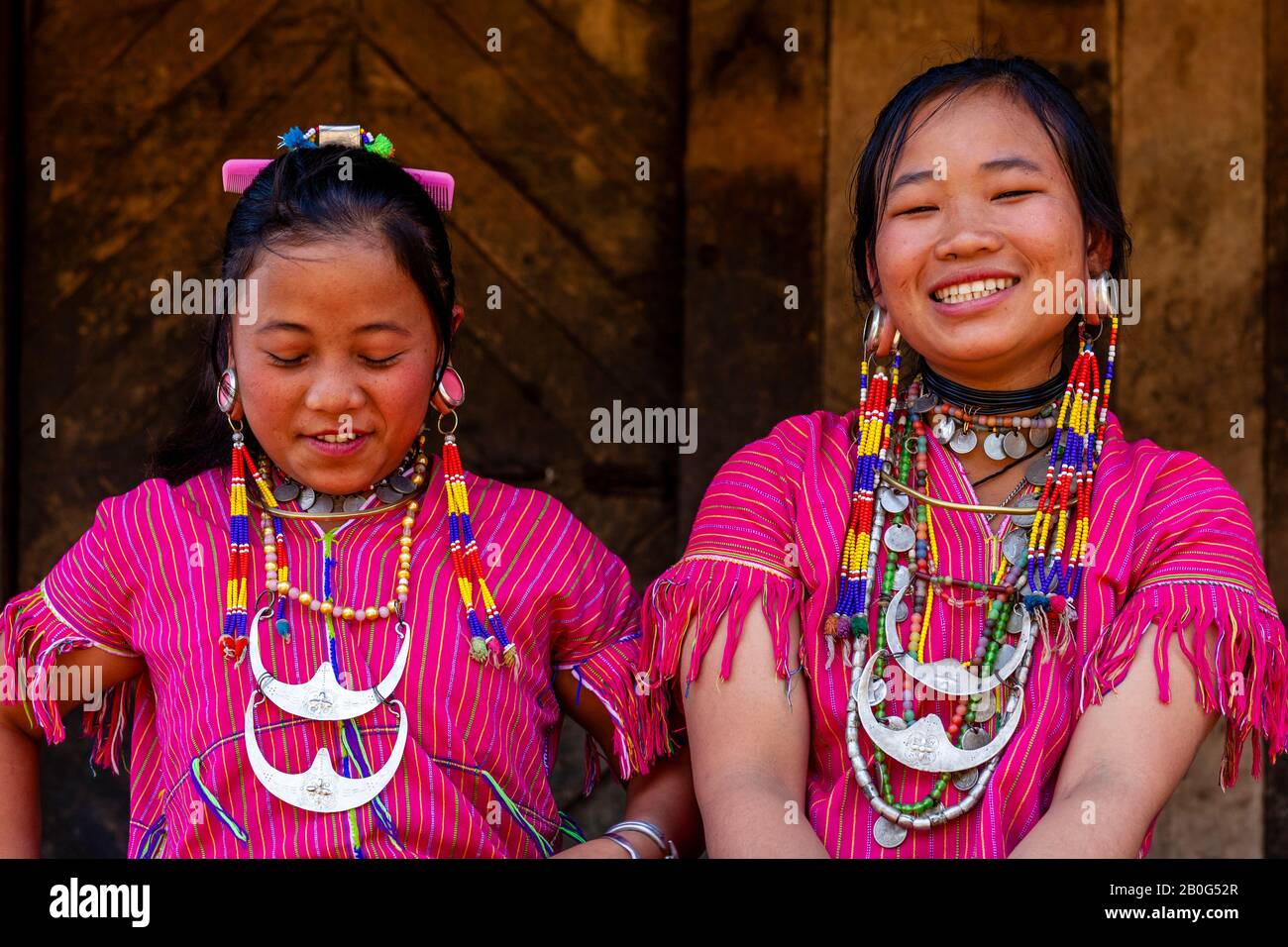 Deux Jeunes Femmes Du Groupe Ethnique Kayaw Assis À L'Extérieur De Leur Maison, Htay Kho Village, Loikaw, Myanmar. Banque D'Images