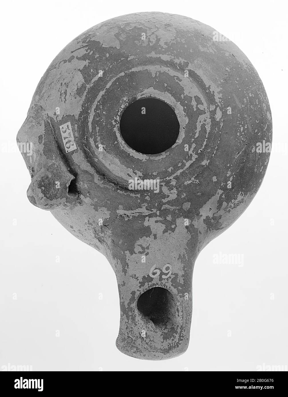 Une lampe à huile noire imbriquée avec un haut corps rond sur une petite base ronde avec un petit trou de remplissage entouré d'une bague encastrée. La goulotte longue est fermée et plate directement par le dessus. Sur la gauche se trouve une grande affleurement foré, lampe à huile, faïence, terre cuite, 5 x 10,5 x 8,2 cm, 3ème siècle avant J.-C. -300 Banque D'Images