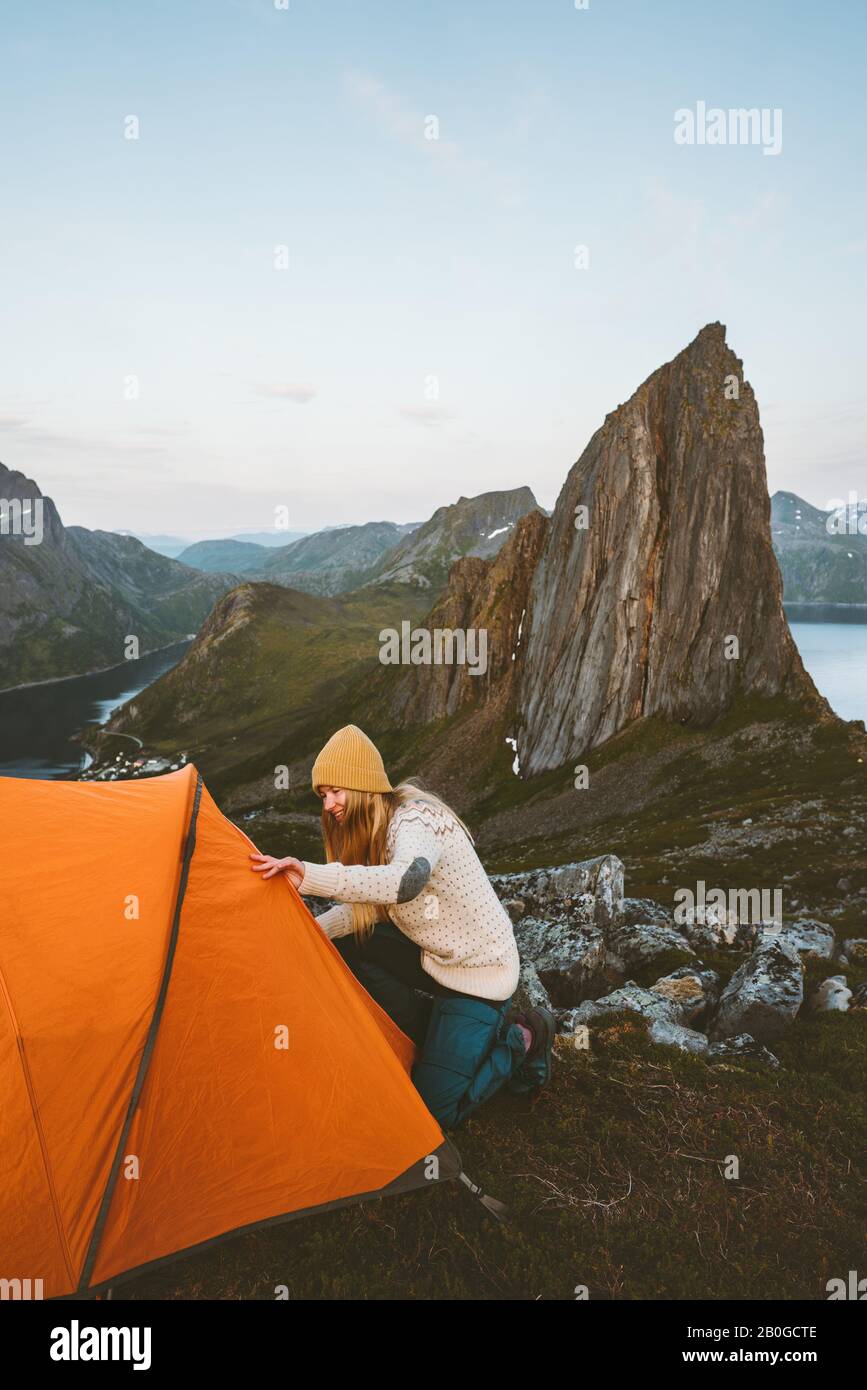 Tente de camping en montagne femme voyageant en Norvège aventure mode de vie sain actif vacances d'été vue sur la montagne de Segla Banque D'Images Tente de camping en montagne femme voyageant en Norvège aventure mode de vie sain actif vacances d'été vue sur la montagne de Segla Banque D'Images