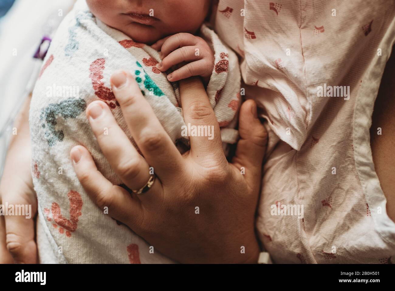 Vue macro de la tête de la mère tenant les doigts du nouveau-né dans hospita Banque D'Images