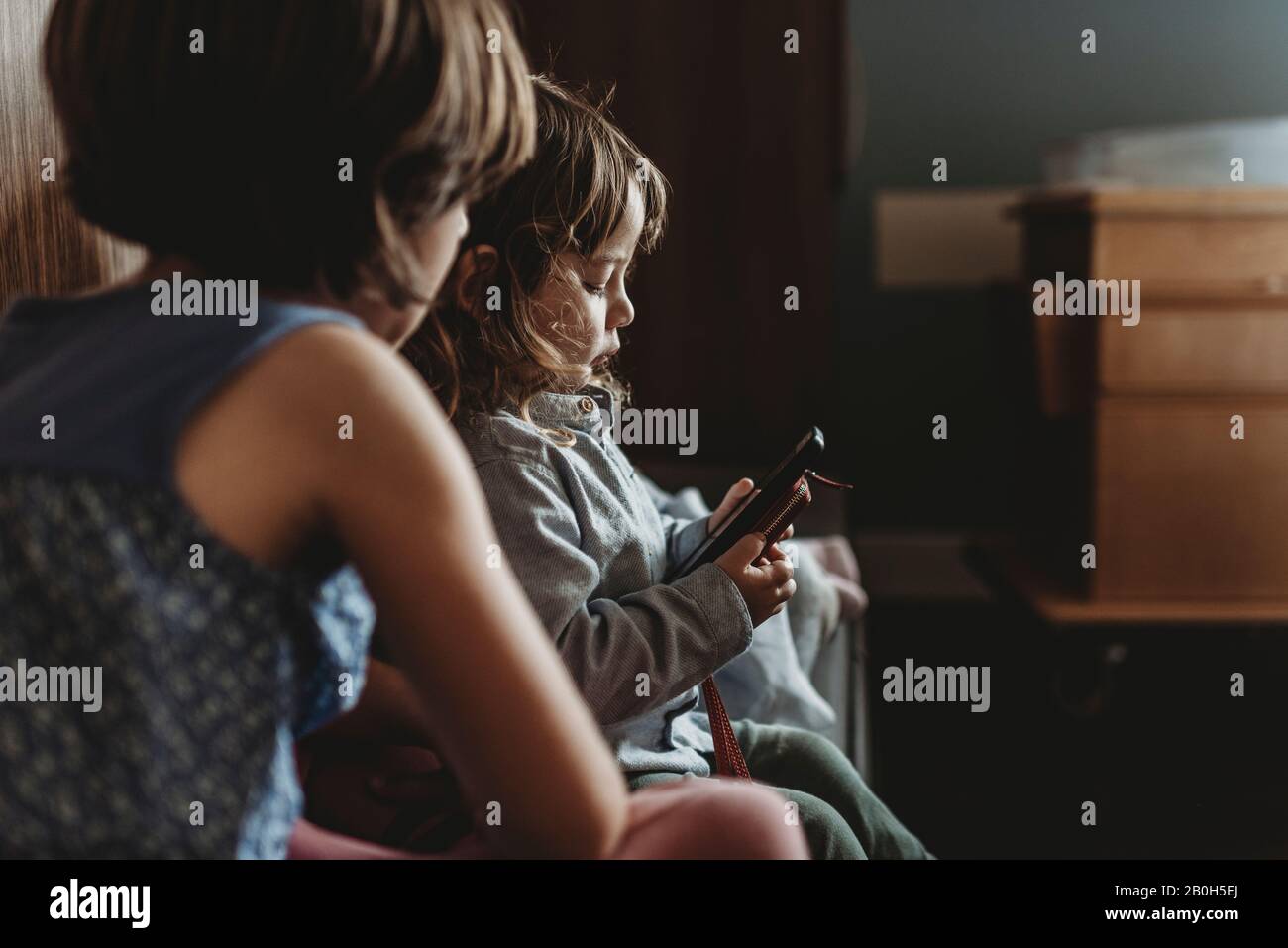 Vue latérale d'un jeune garçon jouant au téléphone à l'hôpital Banque D'Images