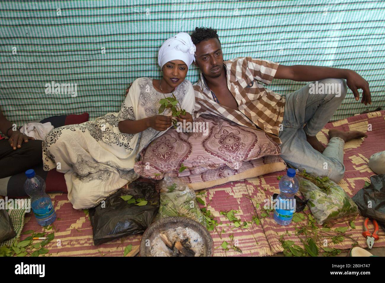 02.11.2019, Adama, Oromiyaa, Ethiopie - un homme et une femme s'assoient à mâcher le khat sur le sol. L'homme possède une succursale de khat. 8000 personnes déplacées à l'intérieur du pays Banque D'Images