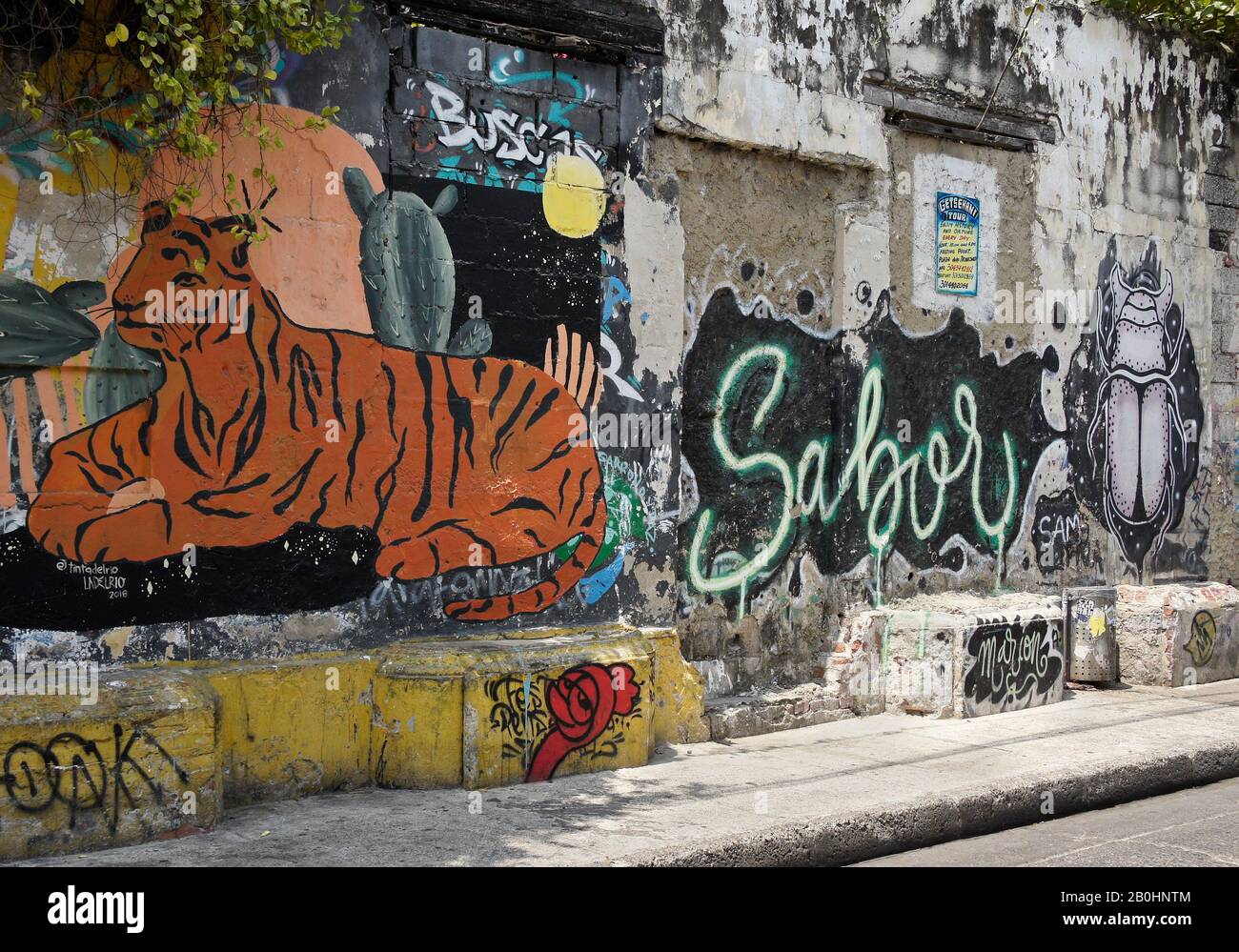 Des œuvres d'art et des graffitis colorés ornent un vieux mur sur la Calle de la Sierpe (Calle 29) à Getsemani, Carthagène, Colombie Banque D'Images