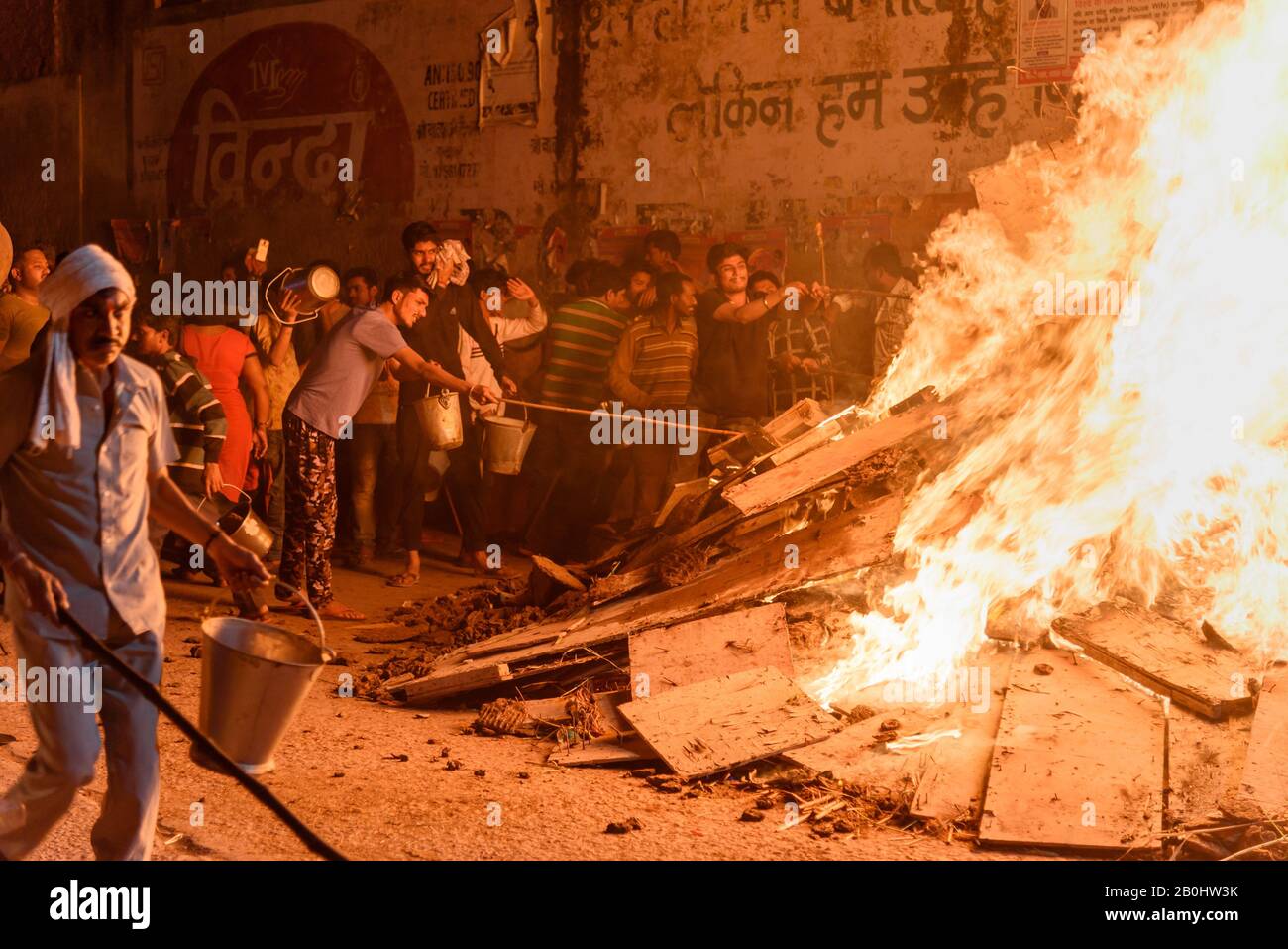 Les gens qui tirent du charbon déportant la figure mythique de Prahlad du feu traditionnel de Halika Dahan sur le festival hindou de Hali. Vrindavan. Inde Banque D'Images