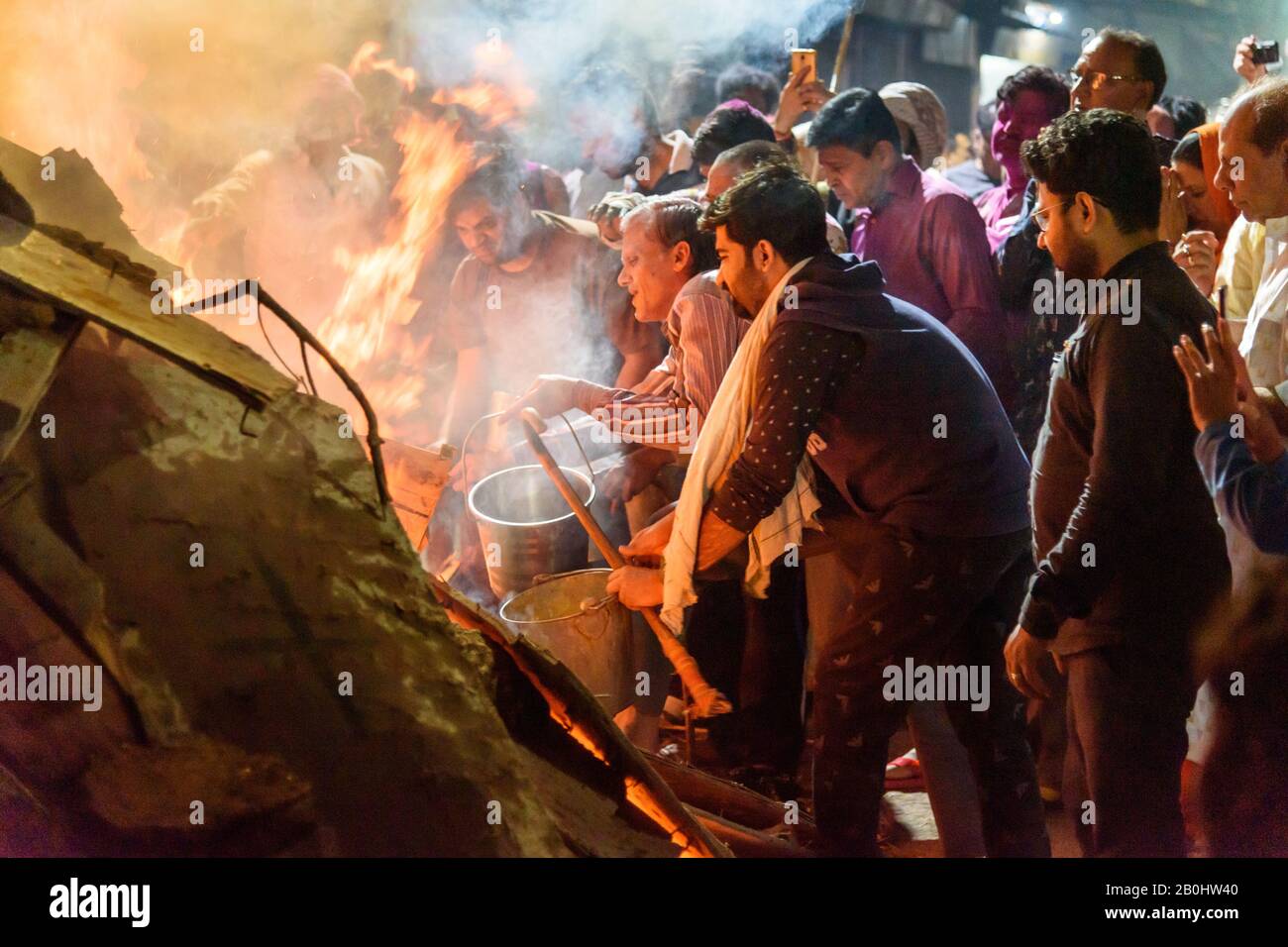 Les gens qui tirent du charbon déportant la figure mythique de Prahlad du feu traditionnel de Halika Dahan sur le festival hindou de Hali. Vrindavan. Inde Banque D'Images