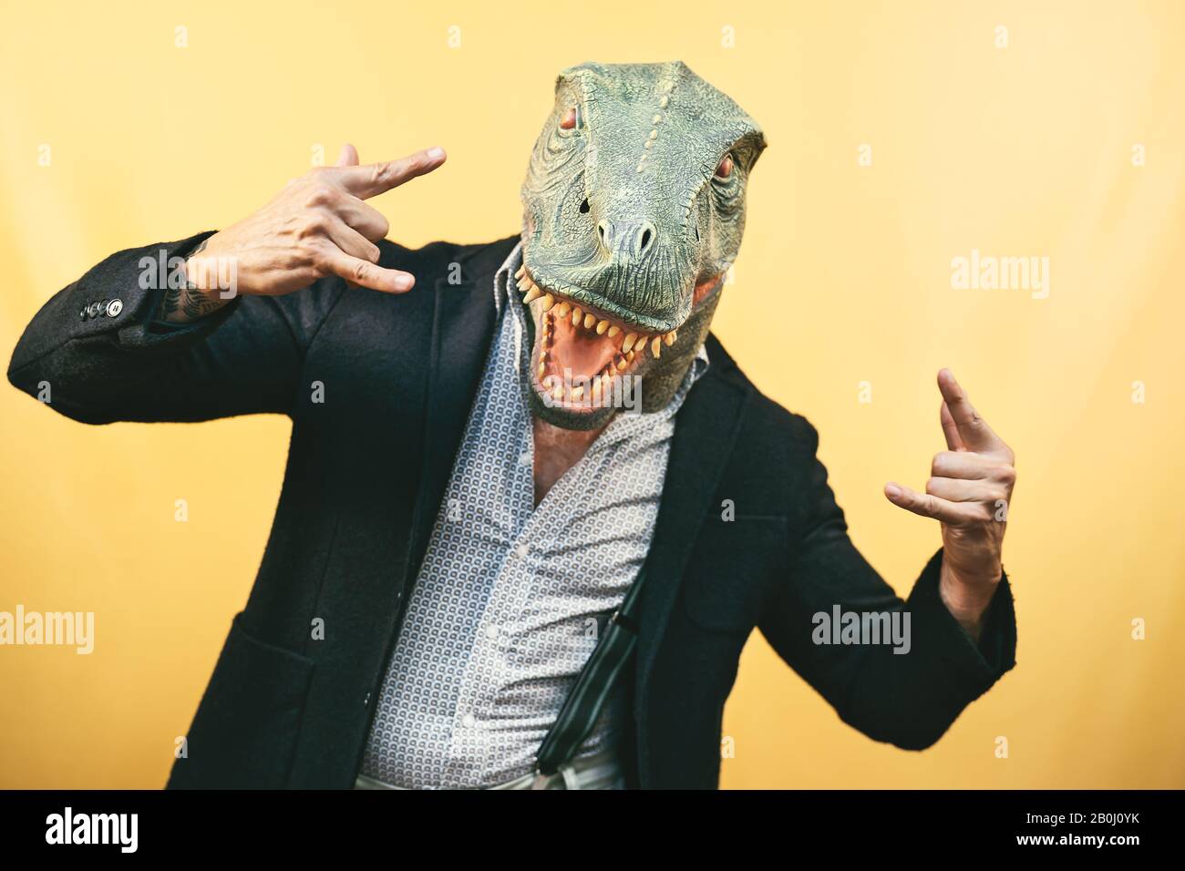 Homme senior portant le masque de dinosaure t-rex - Crazy hipster gars qui s'amuse à célébrer les fêtes de carnaval - Absurd et surréaliste drôle concept Banque D'Images