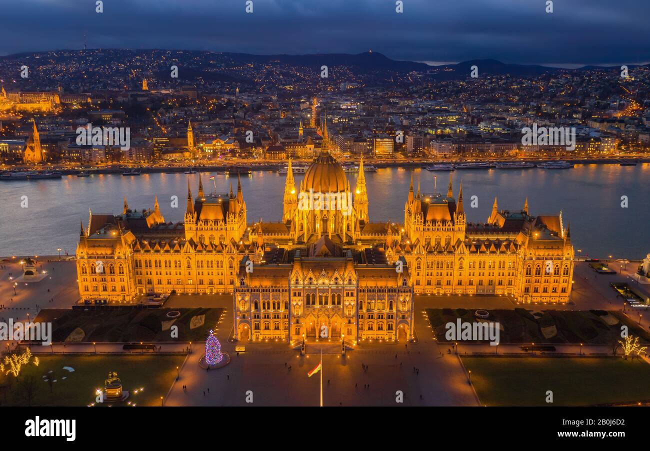 Budapest, Hongrie - vue aérienne du bâtiment lumineux du Parlement hongrois à l'heure d'or avec arbre de Noël et collines de Buda en arrière-plan Banque D'Images