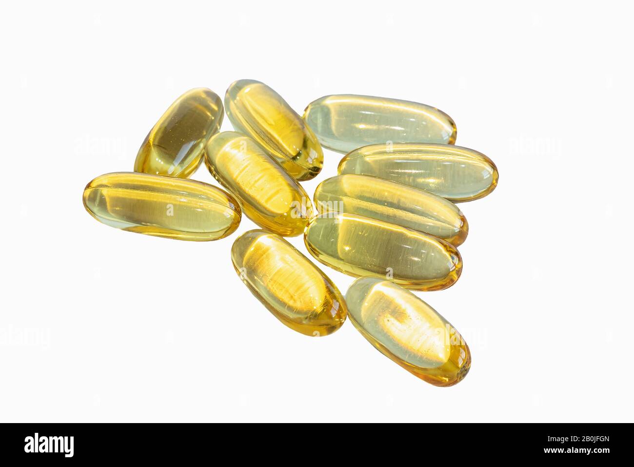 Capsules dorées d'Omega 3 sur fond blanc. Banque D'Images