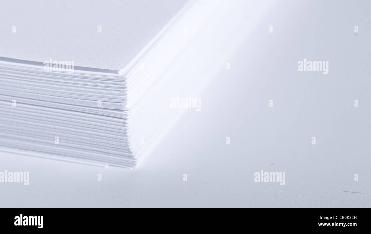 Pile de papier blanc de bureau sur fond clair, vue de dessus, place pour le texte. Banque D'Images