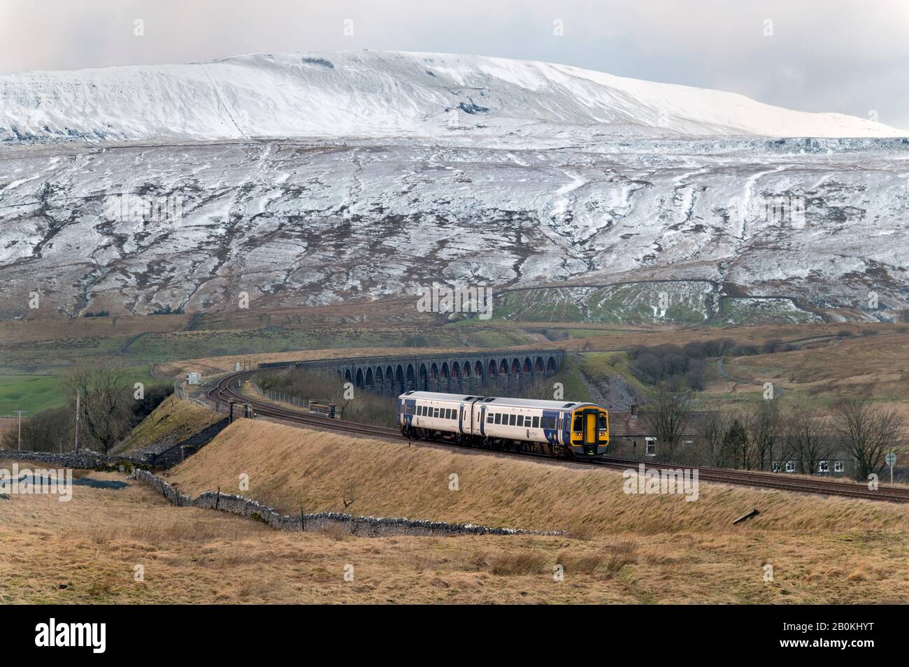 Un train de voyageurs Northern Rail Sprinter traverse le célèbre viaduc Ribblehead dans le parc national du Yorkshire Dales, au Royaume-Uni. Le pic Whernside est derrière. Banque D'Images
