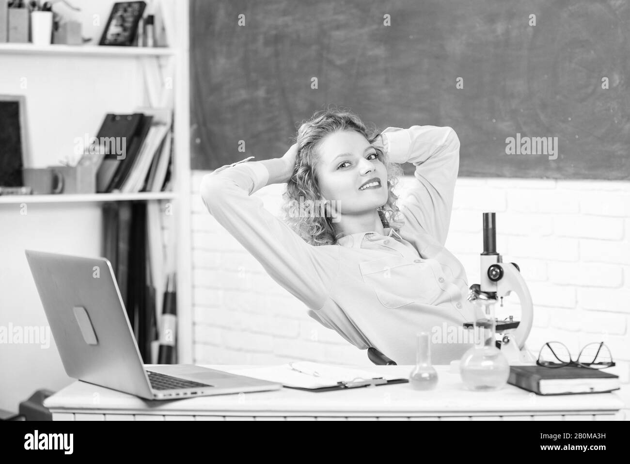 Trouver moyen de se détendre au milieu de travail. Femme adorable professeur essayez de vous détendre dans la salle de classe. Les méthodes de relaxation et de santé mentale. Pédagogue de l'école de l'occupation. L'étirement après une dure journée de travail. Tout simplement se détendre. Banque D'Images