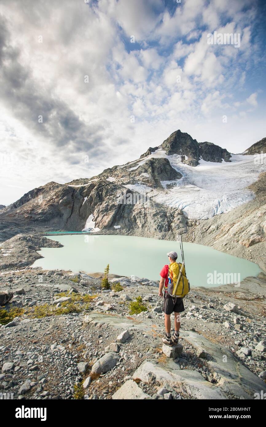 Backpacker s'arrête pour regarder la vue sur les montagnes glacier et lac. Banque D'Images