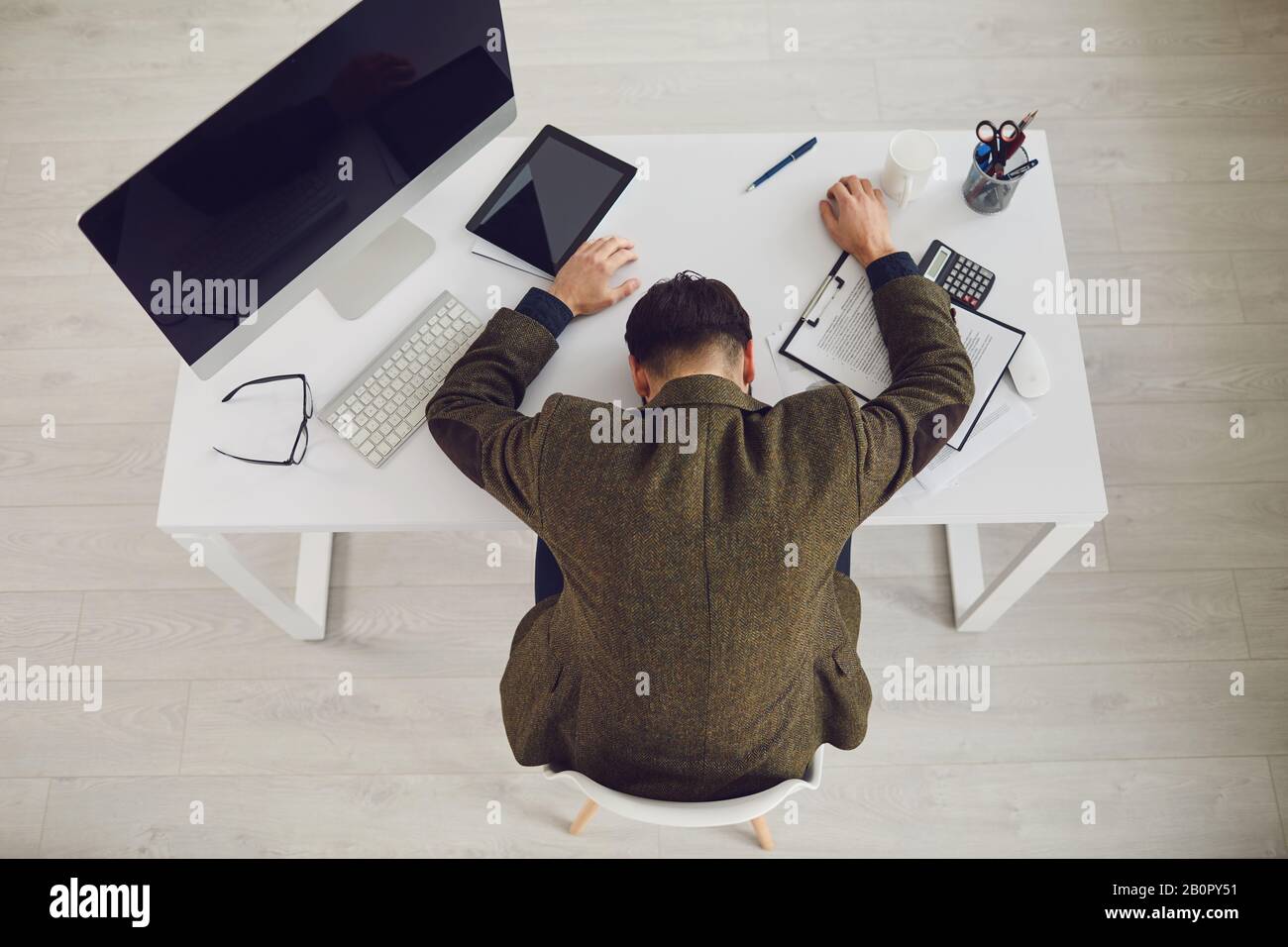 Un homme d'affaires fatigué épuisé dort avec des problèmes de stress au travail au bureau. Banque D'Images
