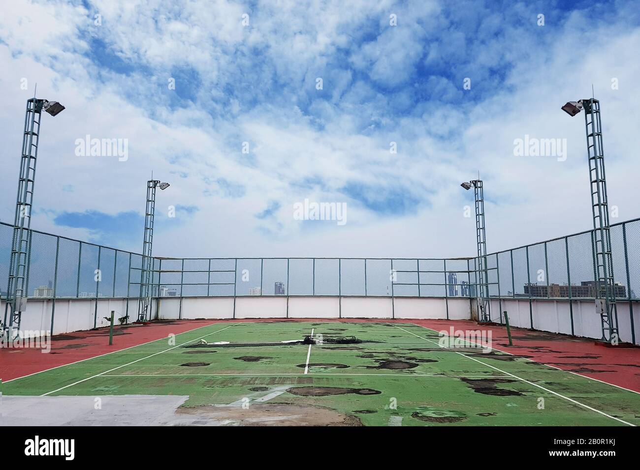 un court de tennis perdu avec casse-sol et déperdition d'eau. l'ancienne condition a détérioré le court de tennis Banque D'Images