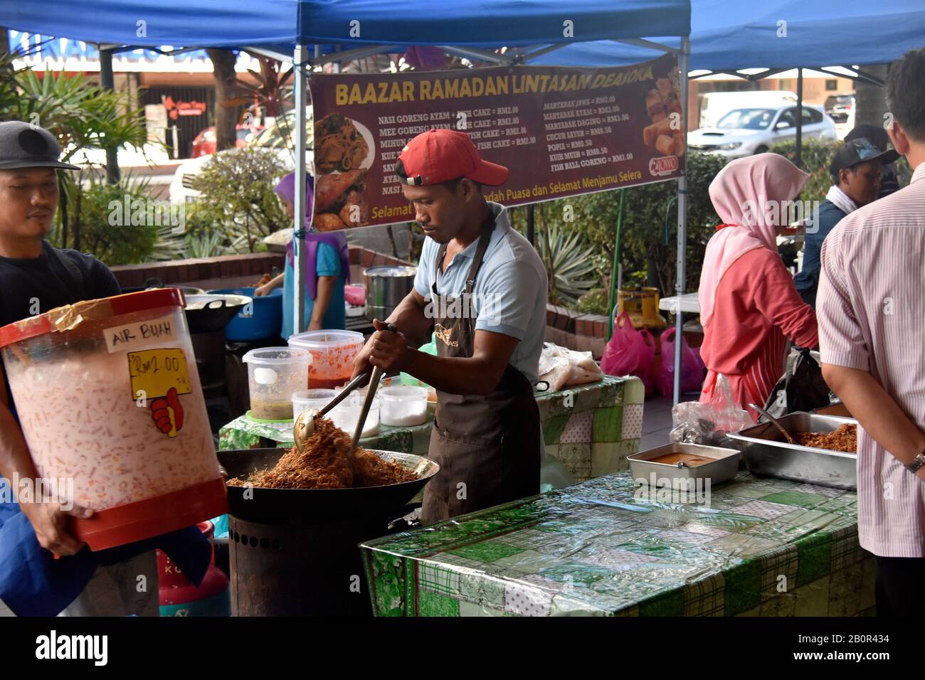 Le vendeur mélange un wok rempli de nouilles dans le marché alimentaire de nuit du Ramadan, Kota Kinabalu, Sabah, Bornéo, Malaisie Banque D'Images