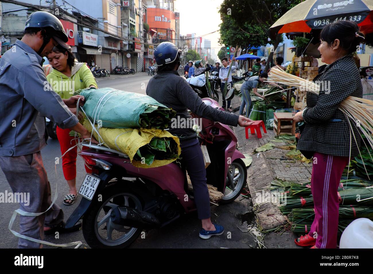 HO CHI MINH VILLE, VIET NAM, marché traditionnel des feuilles près de Tet pour les gens achètent des feuilles, corde de bambou, moule à gâteau pour faire le gâteau de riz gluant Banque D'Images