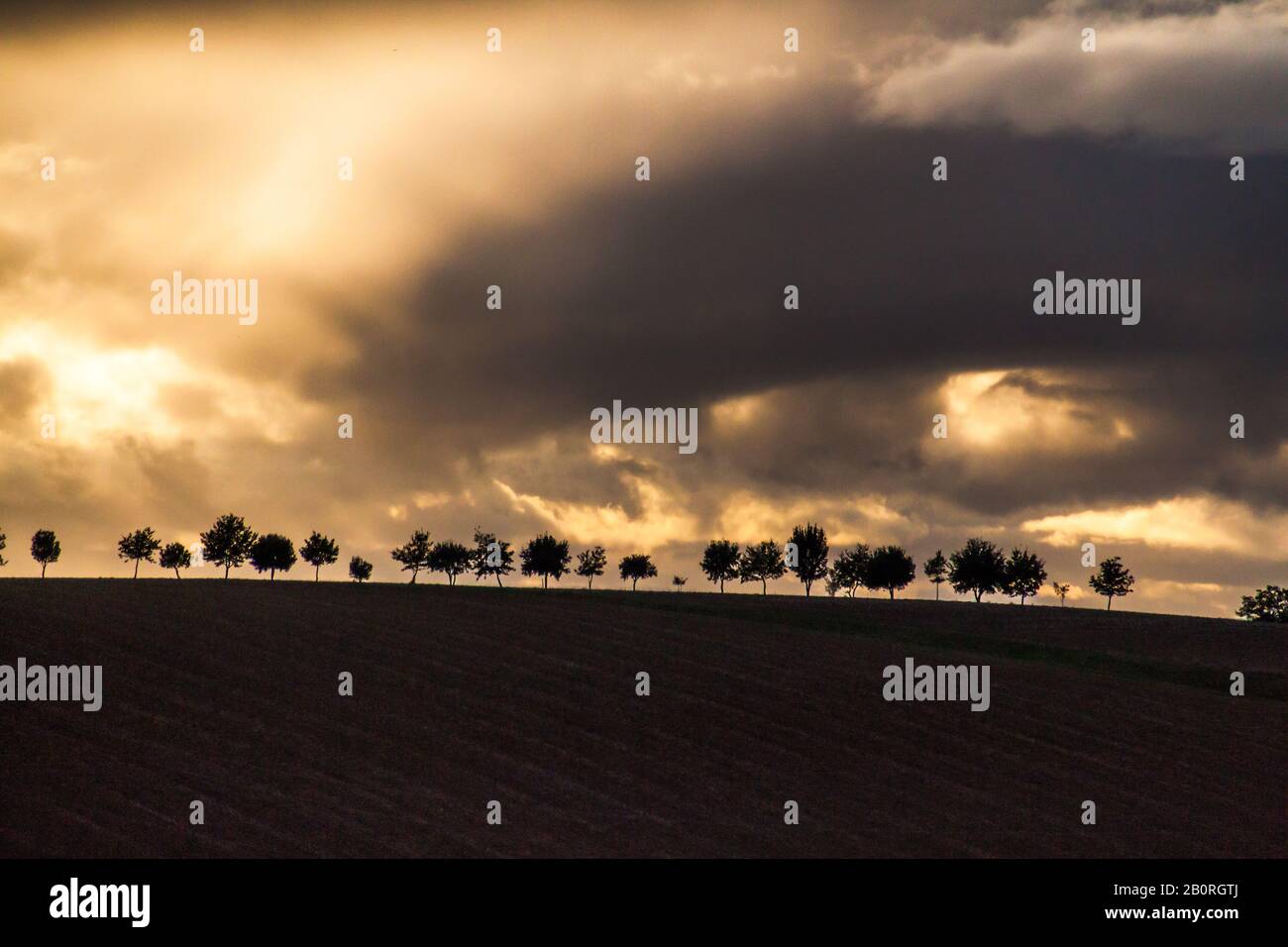 Coucher de soleil spectaculaire et ciel couvert de Stormy au-dessus du paysage des collines de Rolling dans le sud de la France Banque D'Images