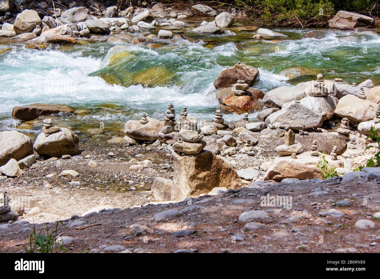 Harmonie, équilibre et simplicité concept. Une pyramide de pierre sur le fond de l'eau de rivière. Galets poise simples, rock zen. Bleu, vie. Banque D'Images